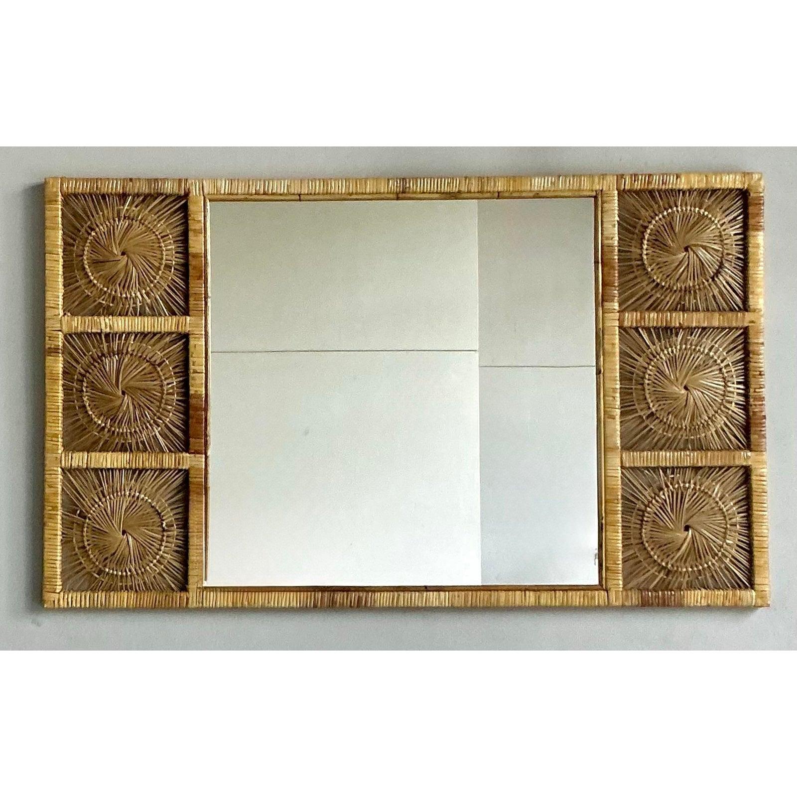Élevez votre espace de vie avec ce captivant miroir vintage en rotin, véritable incarnation de l'élégance bohème et de l'allure naturelle. Fabriquée dans les années 1970, cette pièce présente un cadre en rotin tressé de façon complexe, orné de six