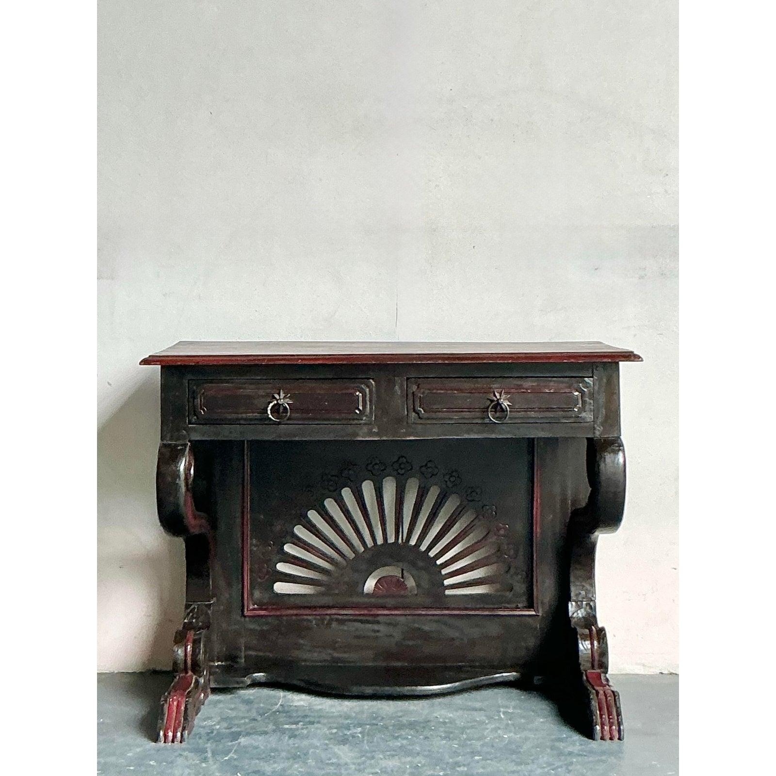 Infuse your living space with the rustic charm and global appeal of this vintage Boho console table, crafted from richly patinated reclaimed wood. This unique piece features a robust tabletop and two functional drawers adorned with intricate carved