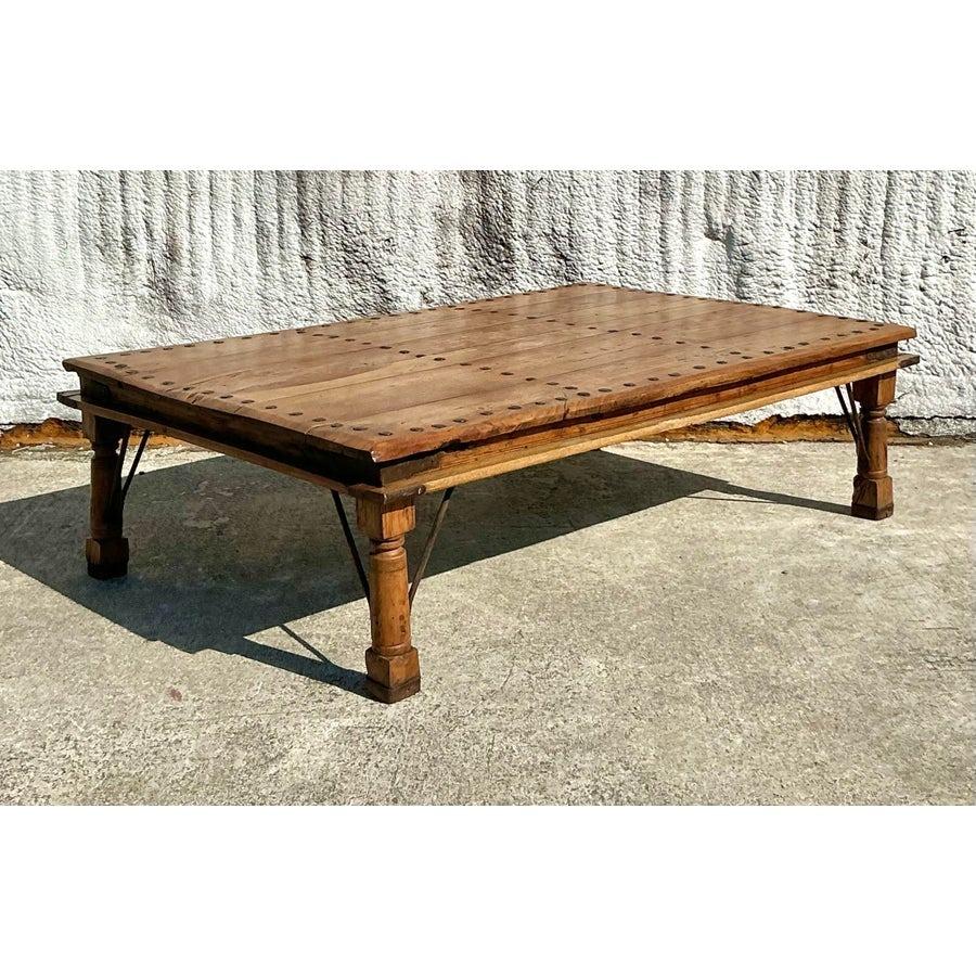 Élevez votre espace de vie avec cette table basse en bois récupéré vintage boho saisissante. Dotée d'un plateau en bois richement grainé orné d'audacieux accents de tête de clou, cette table respire le charme rustique et l'élégance bohème. Les