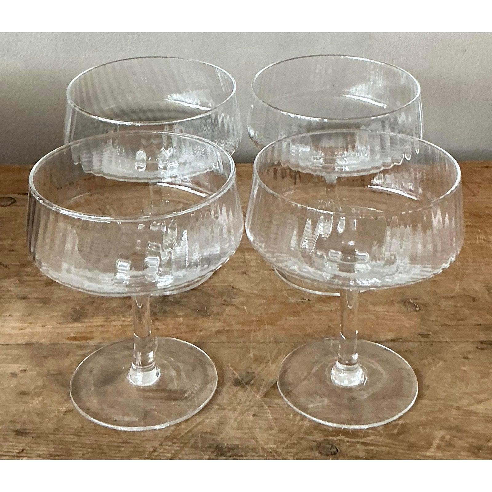 Mit diesem exquisiten Set aus vier gerippten Vintage-Coupé-Gläsern, die den Charme der Bohème mit klassischer Raffinesse verbinden, können Sie Ihren Gästen eine Freude machen. Jedes Glas weist ein wunderschön strukturiertes, geripptes Design auf,