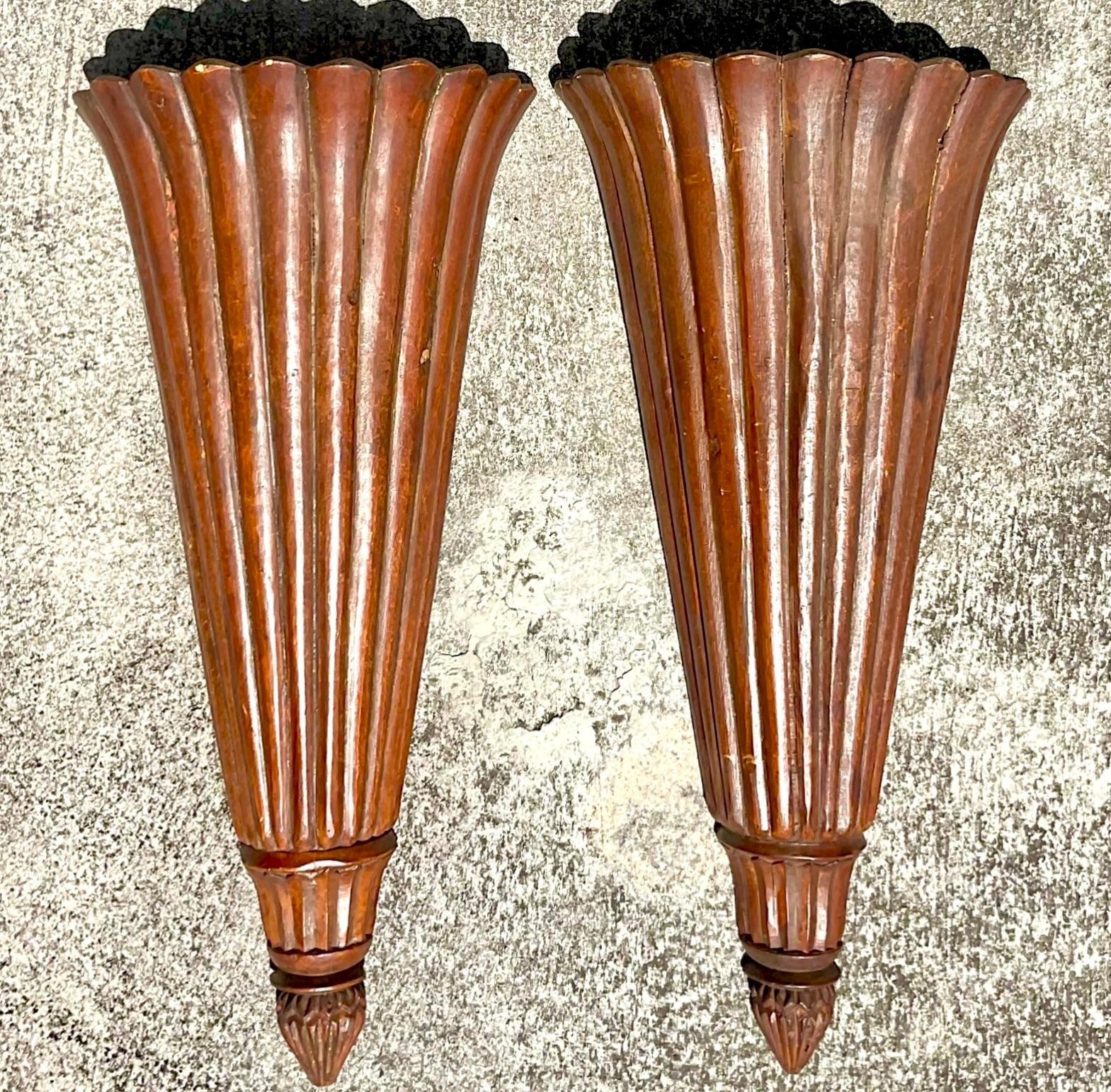 A stunning pair of vintage Boho wall sconces. A super chic pair of carved wood trumpet shaped fixtures with a ribbed design. Acquired from a Palm Beach estate.