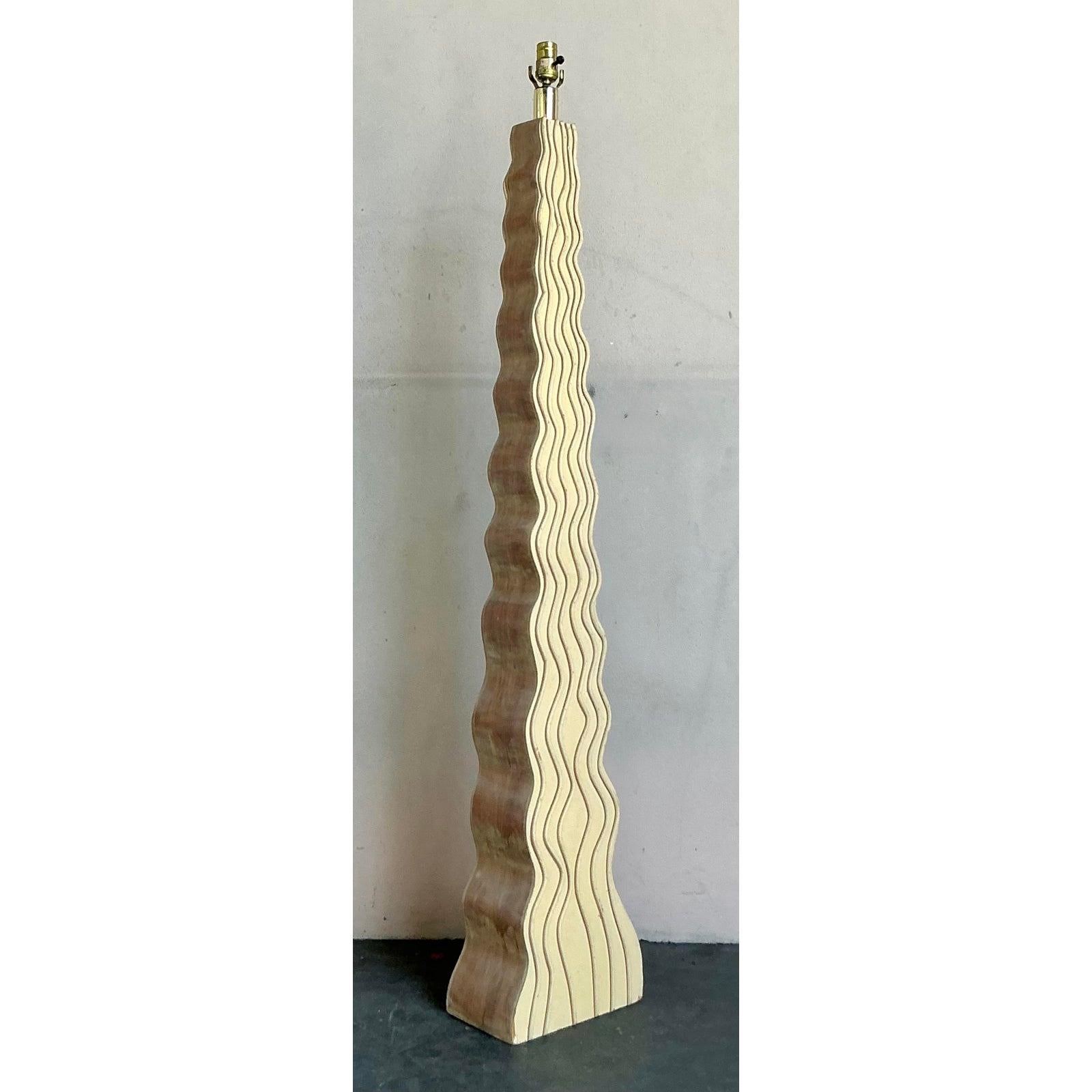 Illuminate your space with the architectural elegance of this stunning vintage ripple floor lamp. A brilliant example of 1980s Postmodern design, the lamp's towering column features a captivating, continuous wave or ripple motif that creates a