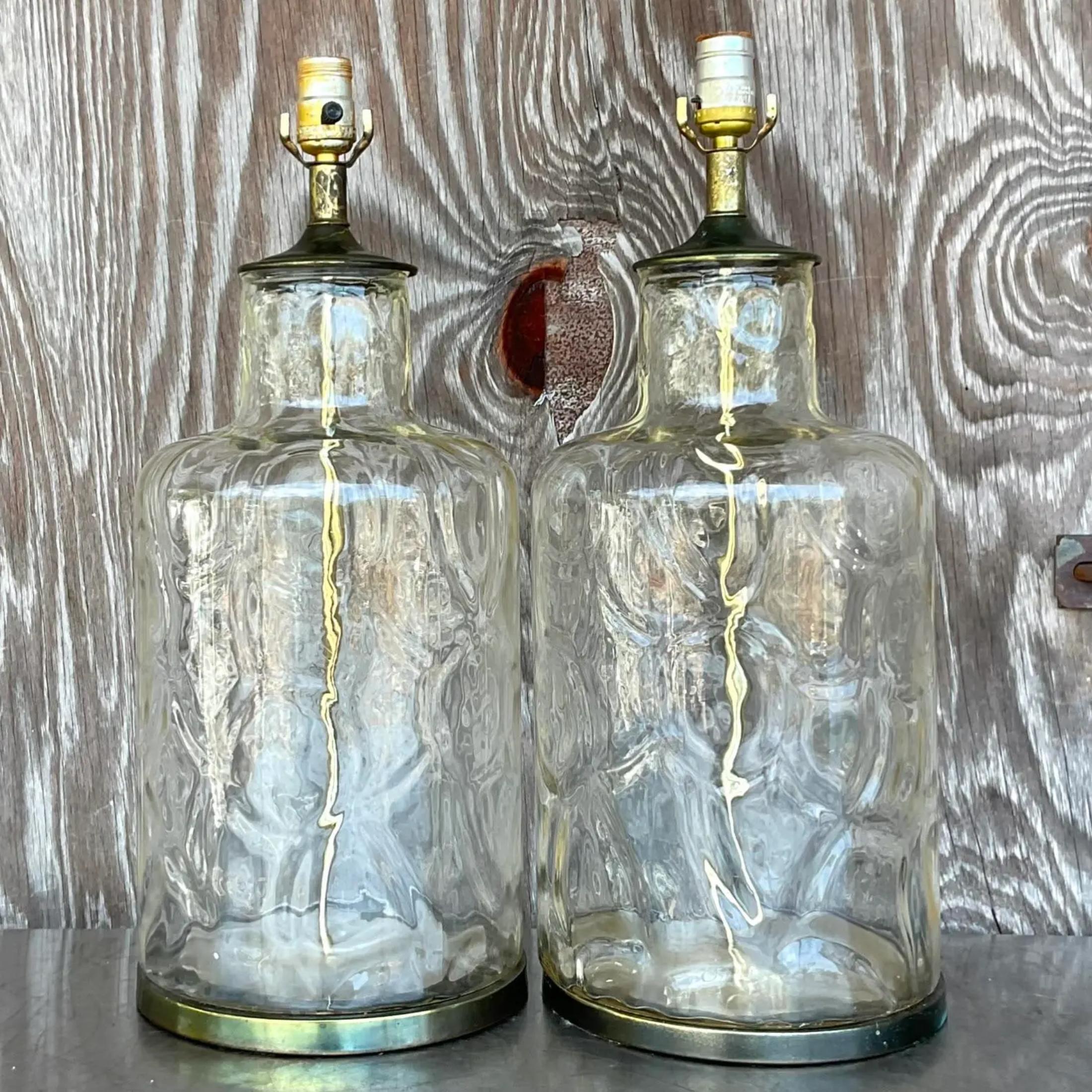 Une fabuleuse paire de lampes de table Boho vintage. Un corps en verre ondulé transparent chic avec des accessoires en laiton bruni. Acquis d'une propriété de Palm Beach. 