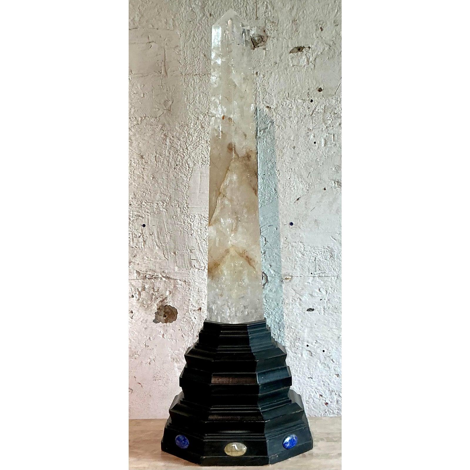 A truly monumental and dramatic statement piece, this vintage obelisk is a tour de force of natural beauty and sophisticated design. The massive spire is hand-carved from a single specimen of genuine rock crystal, its translucent depths alive with
