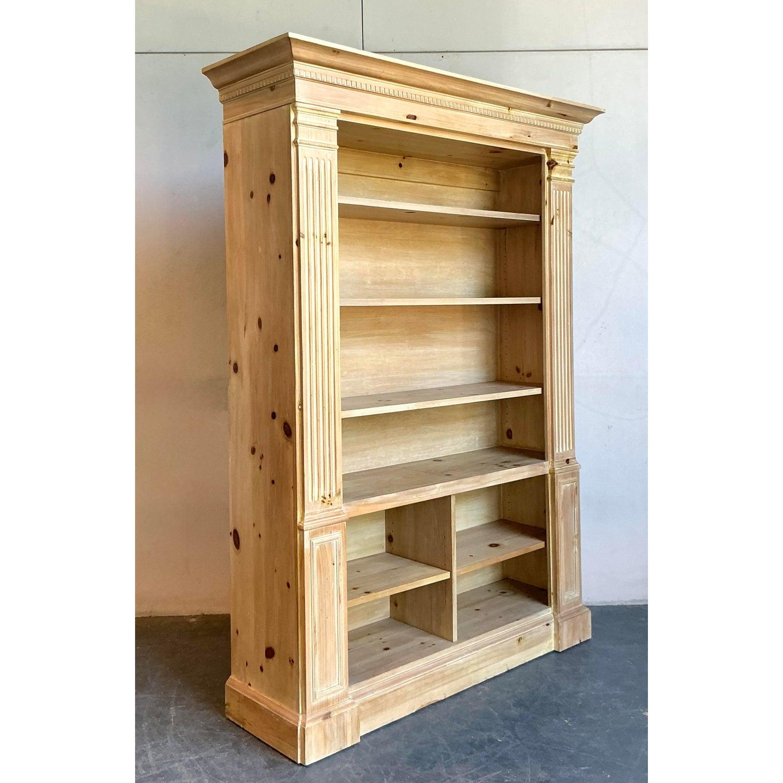 A monumental piece of American craftsmanship, this étagère from the esteemed Romweber Furniture Company exudes a powerful, architectural presence. Masterfully constructed from solid knotty pine, its design features stately Neoclassical elements,