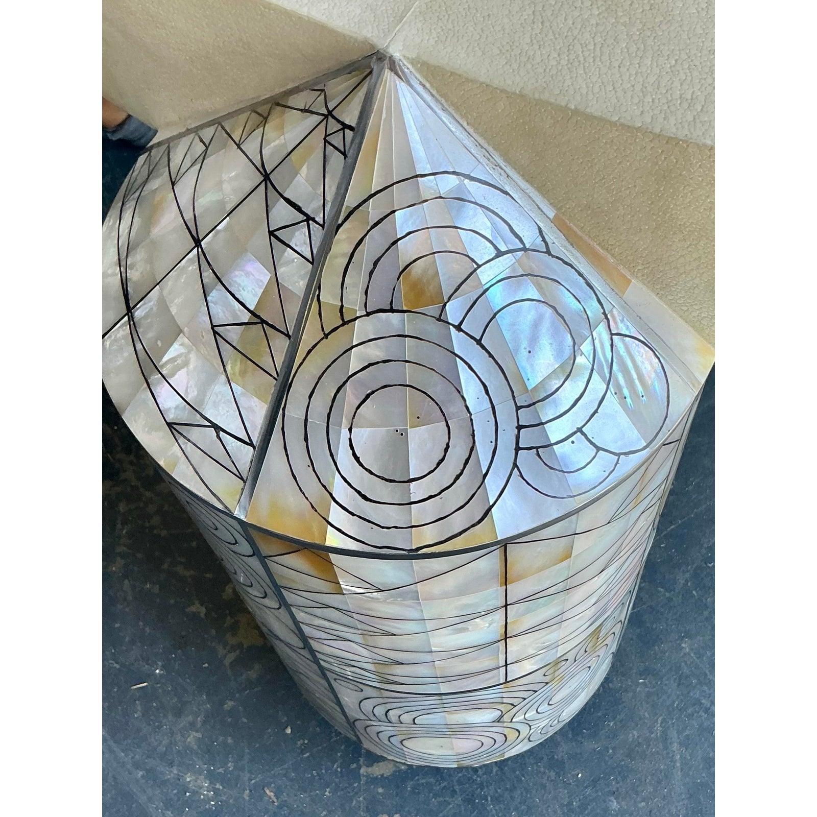 Presentamos una magnífica mesa de centro vintage, inspirada en los icónicos diseños de Ron Seff, con exquisitas incrustaciones de nácar y una llamativa tapa de cristal. Esta pieza irradia el glamour de la Regencia de Hollywood con un toque boho