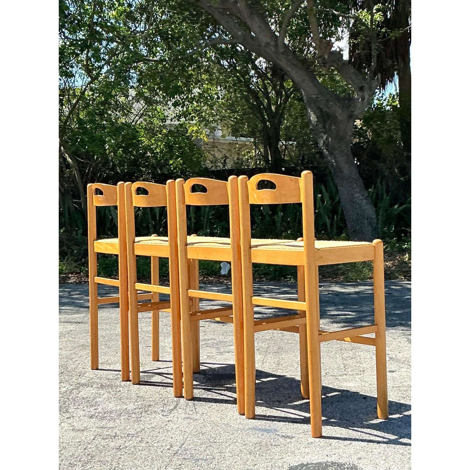 Elevate your space with this charming set of four Vintage Boho Rush Seat Bar Stools, a perfect blend of rustic craftsmanship and timeless design. Crafted from solid wood with a warm natural finish, these stools feature intricately woven rush seats