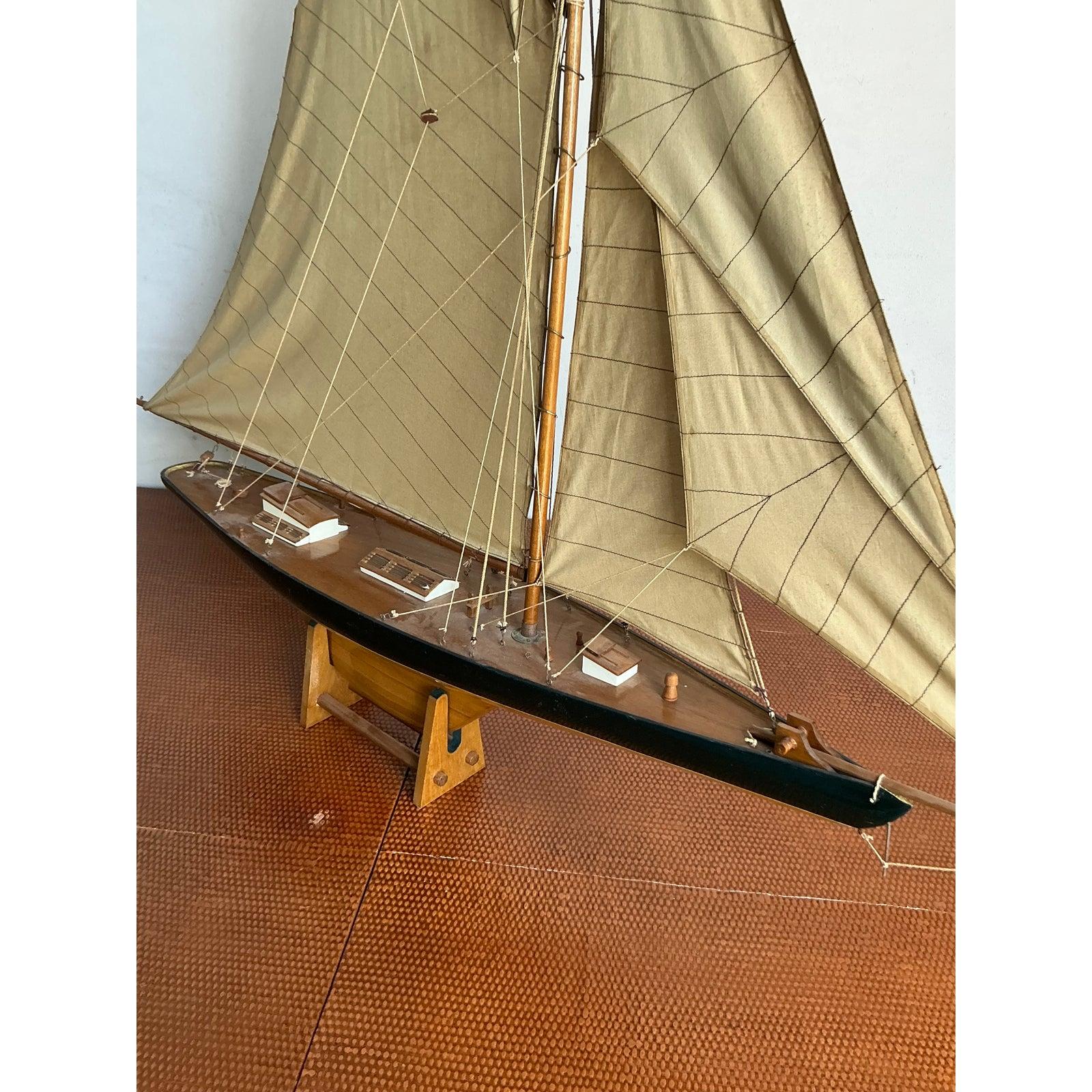 Evoke the timeless allure of maritime adventures with this exquisite vintage sailboat scale model. Crafted with meticulous attention to detail, this piece captures the elegance of early 20th-century yacht design, perfect for collectors and