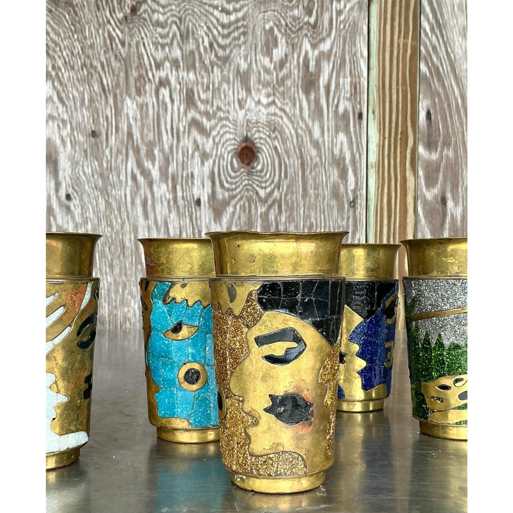 Ce superbe ensemble de huit gobelets en mosaïque de laiton Salvador Teran est un véritable témoignage de l'artisanat d'art. Chaque gobelet est conçu de manière unique avec des incrustations de mosaïque représentant des visages abstraits et des