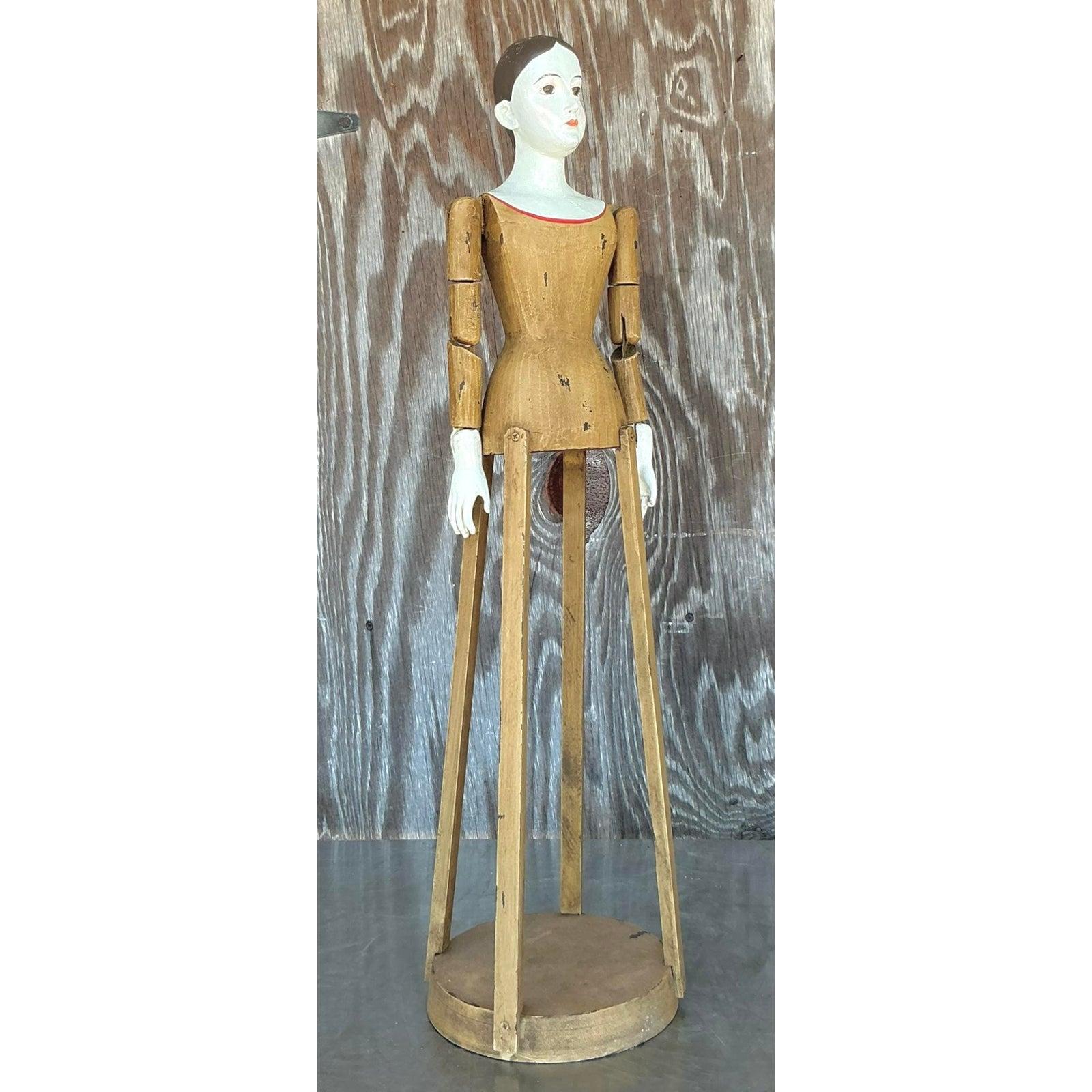 Un pezzo sorprendente di arte popolare devozionale, questa bambola-gabbia vintage di Santos è uno studio di splendidi contrasti. La figura è intagliata a mano nel legno, con braccia articolate e una base tradizionale in stile gabbia, mentre il corpo