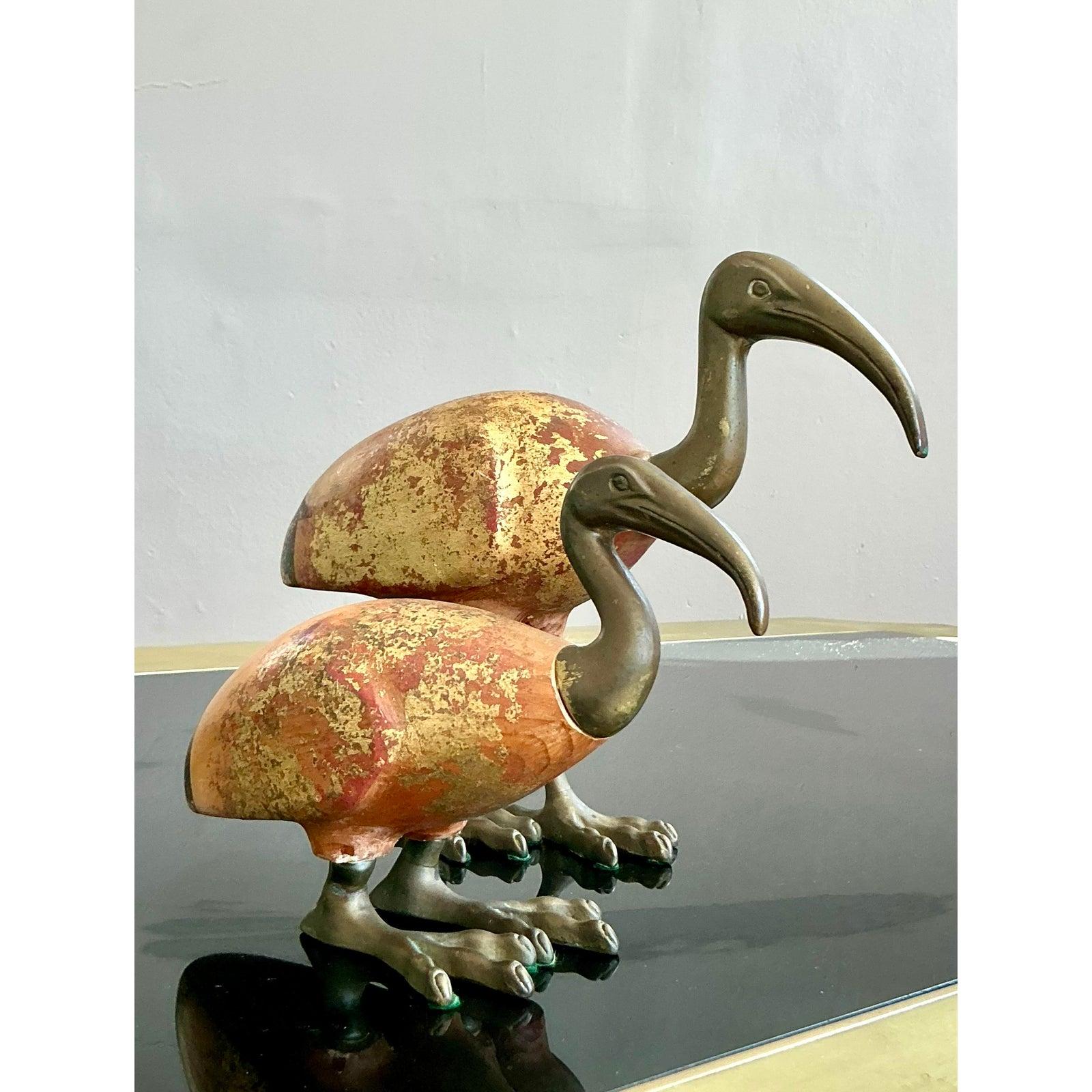 Invita il fascino grazioso della fauna esotica nella tua casa con questo eccezionale set di due sculture di uccelli Ibis Vintage della rinomata Sarreid Ltd. di Spagna. Questi affascinanti pezzi fondono magnificamente i materiali, con teste, gambe e