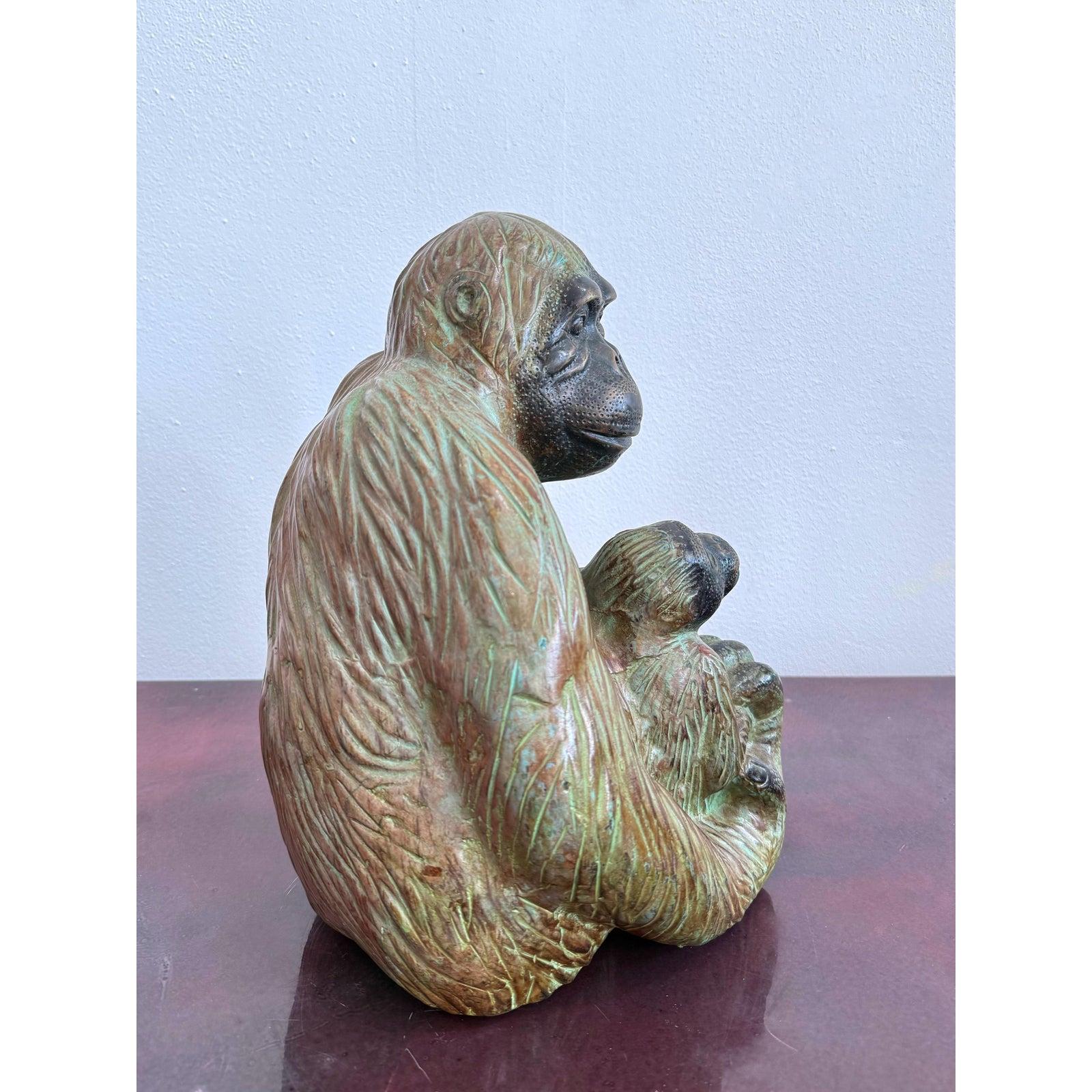 Questa espressiva scultura in metallo cattura il tenero legame tra una madre gorilla e il suo piccolo con notevole calore e consistenza. Fuso in un metallo ricco e dai toni terrosi con patina verde e bronzo, il pezzo enfatizza i contorni fluenti
