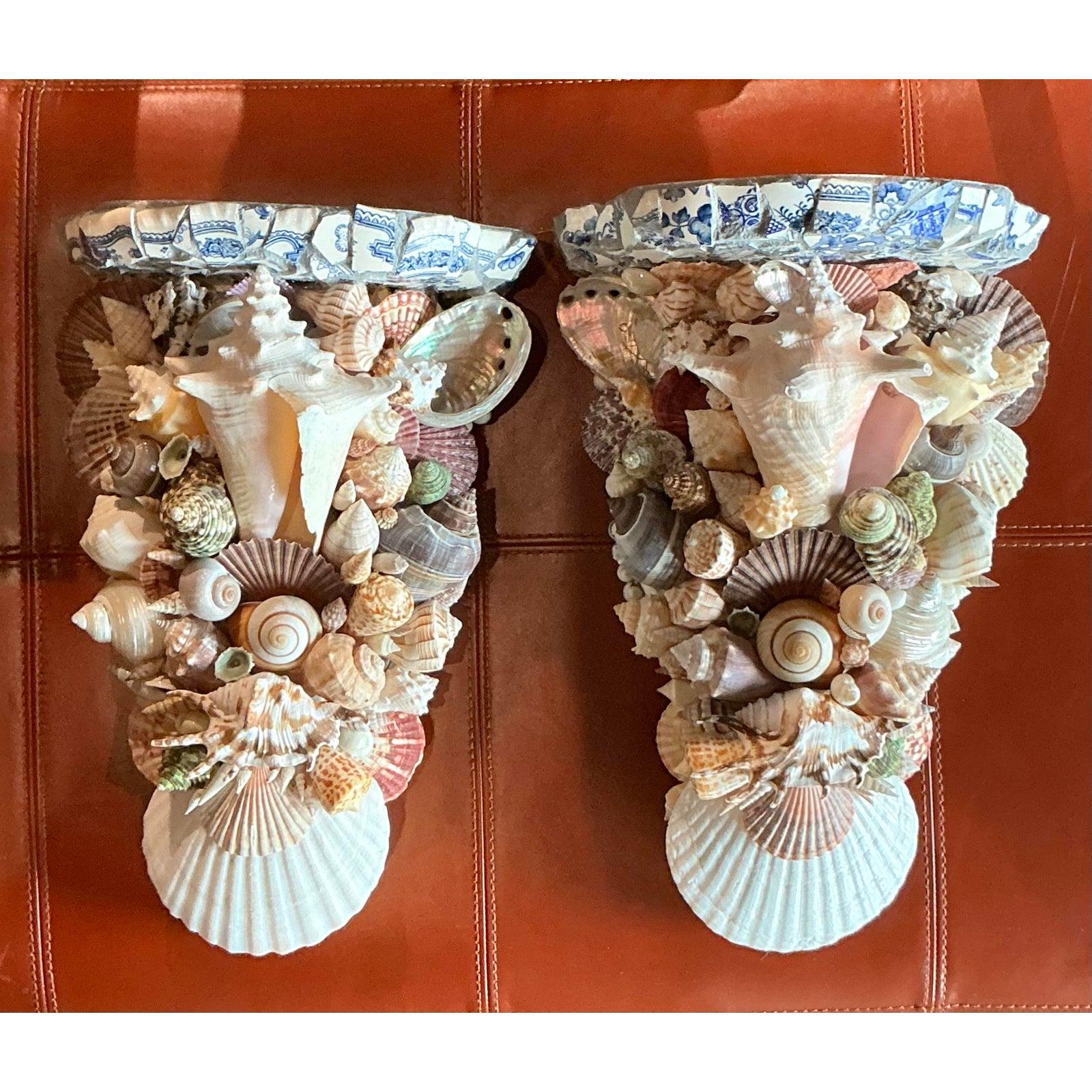 Dieses außergewöhnliche Paar Wandhalterungen mit Muschelkruste im Vintage-Stil versprüht einen Hauch von Küsten-Maximalismus. In sorgfältiger Handarbeit gefertigt, ist jeder Kragstein eine Trove aus dem Meer mit einer kunstvollen Kaskade echter