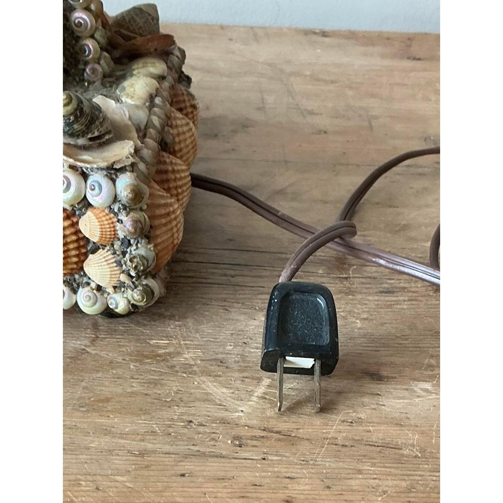 Embrace the serene beauty of the seaside with this enchanting vintage Boho shell-encrusted table lamp, a truly unique piece that brings the tranquility of the ocean into your home. This handcrafted lamp features a meticulously adorned base and stem,