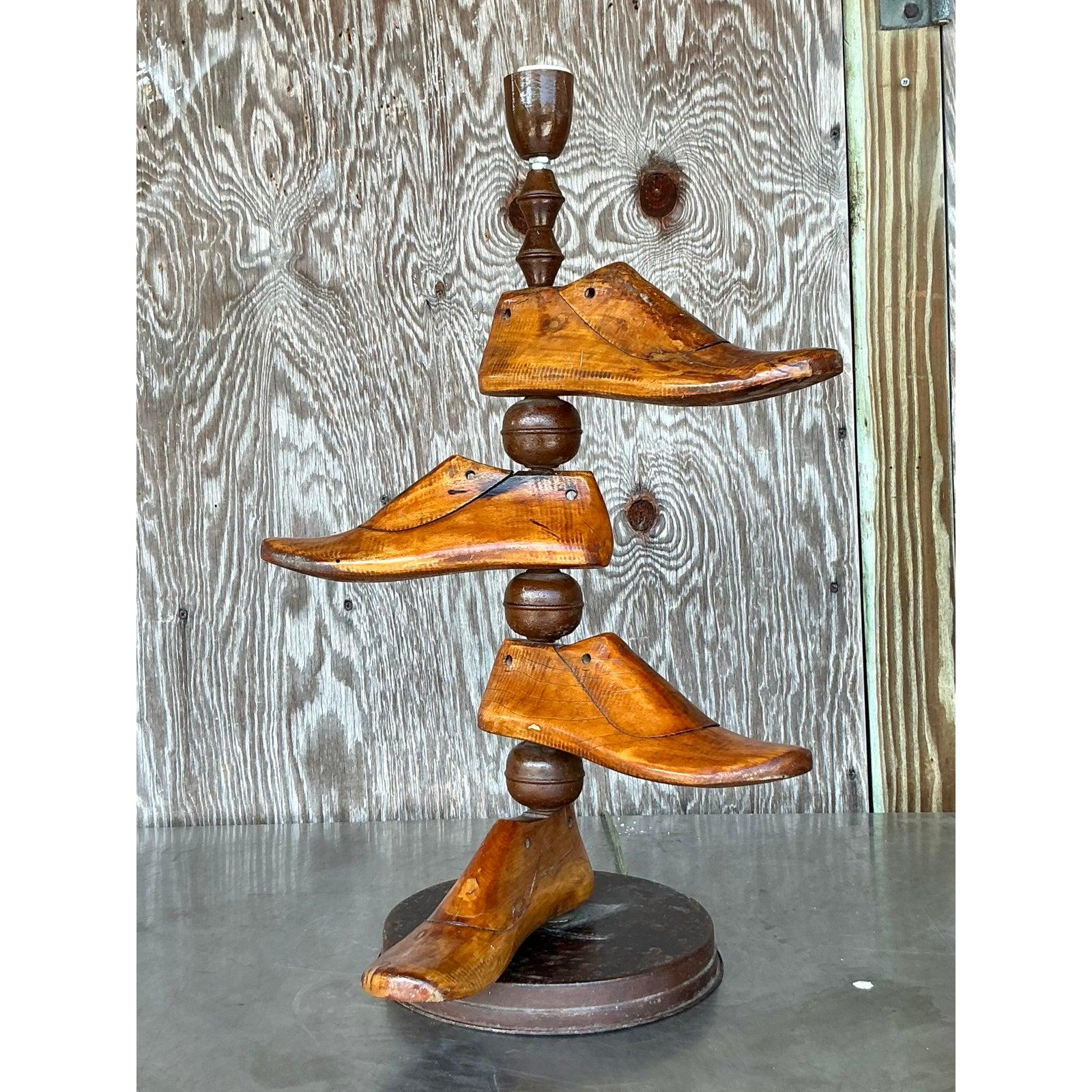 Illuminez votre espace avec un caractère extraordinaire grâce à cette captivante lampe moule à chaussures Vintage Boho. Fabriquée avec ingéniosité à partir d'authentiques formes de chaussures en bois usées par le temps, cette pièce d'éclairage
