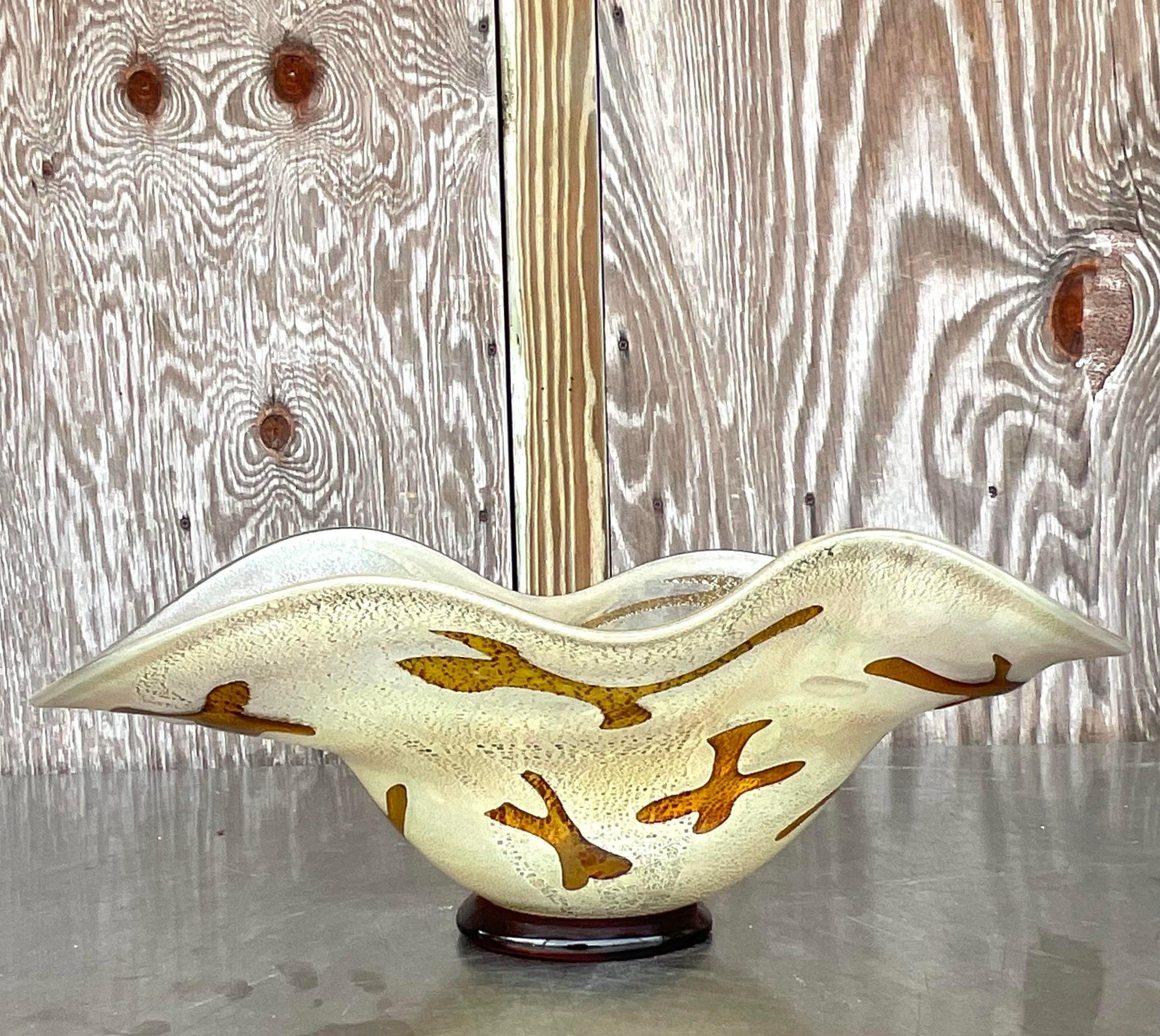Add artistic flair to your home with this Vintage Boho Signed Art Glass Bowl. Featuring unique, handcrafted details and vibrant colors, this bowl embodies bohemian elegance. The artist's signature and expert American craftsmanship make it a stunning