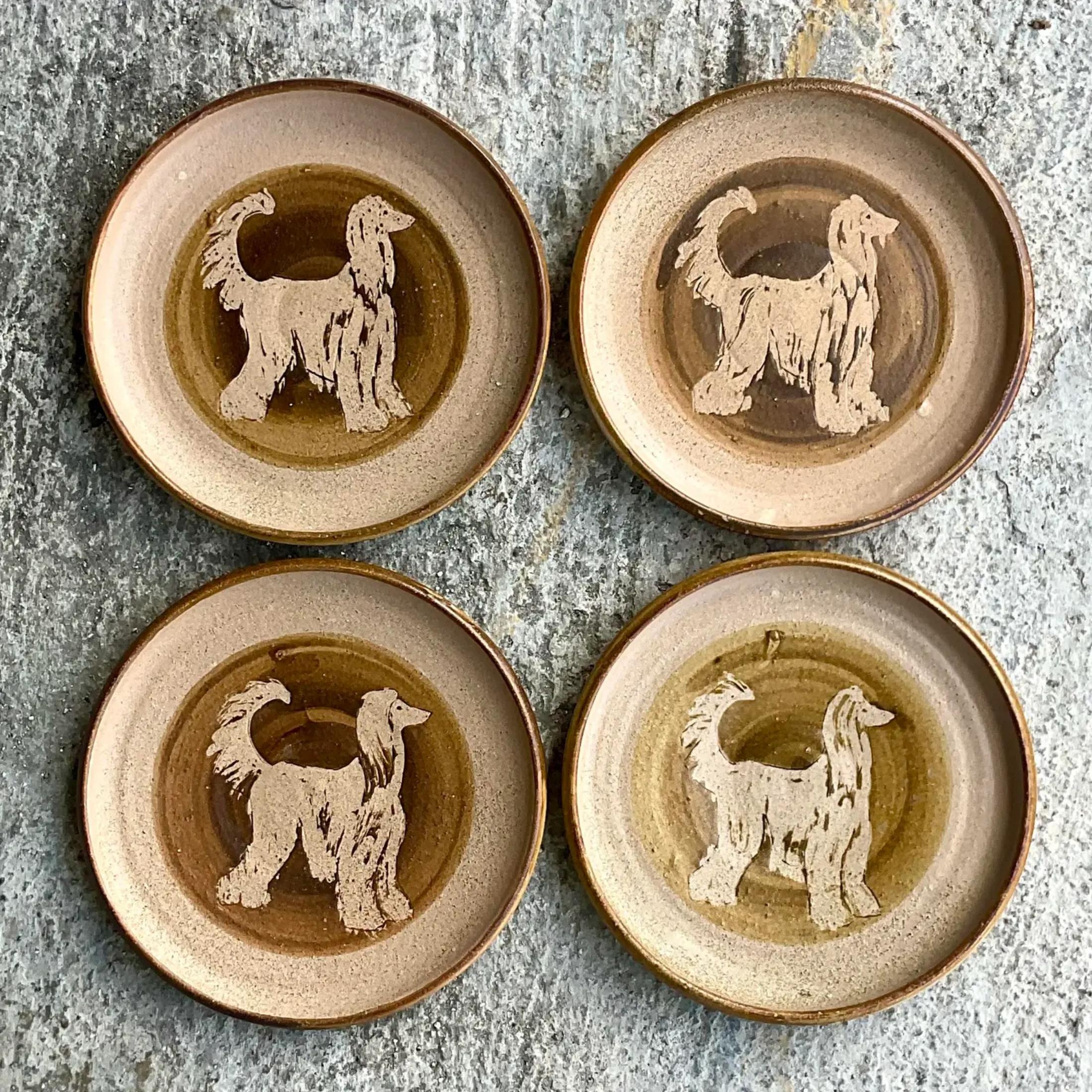 A fabulous set of four vintage plates. Beautiful hand made studio pottery plates with artist signature on the back of each. A chic Afghan dog design in the center of each plate. Acquired from a Palm Beach estate.