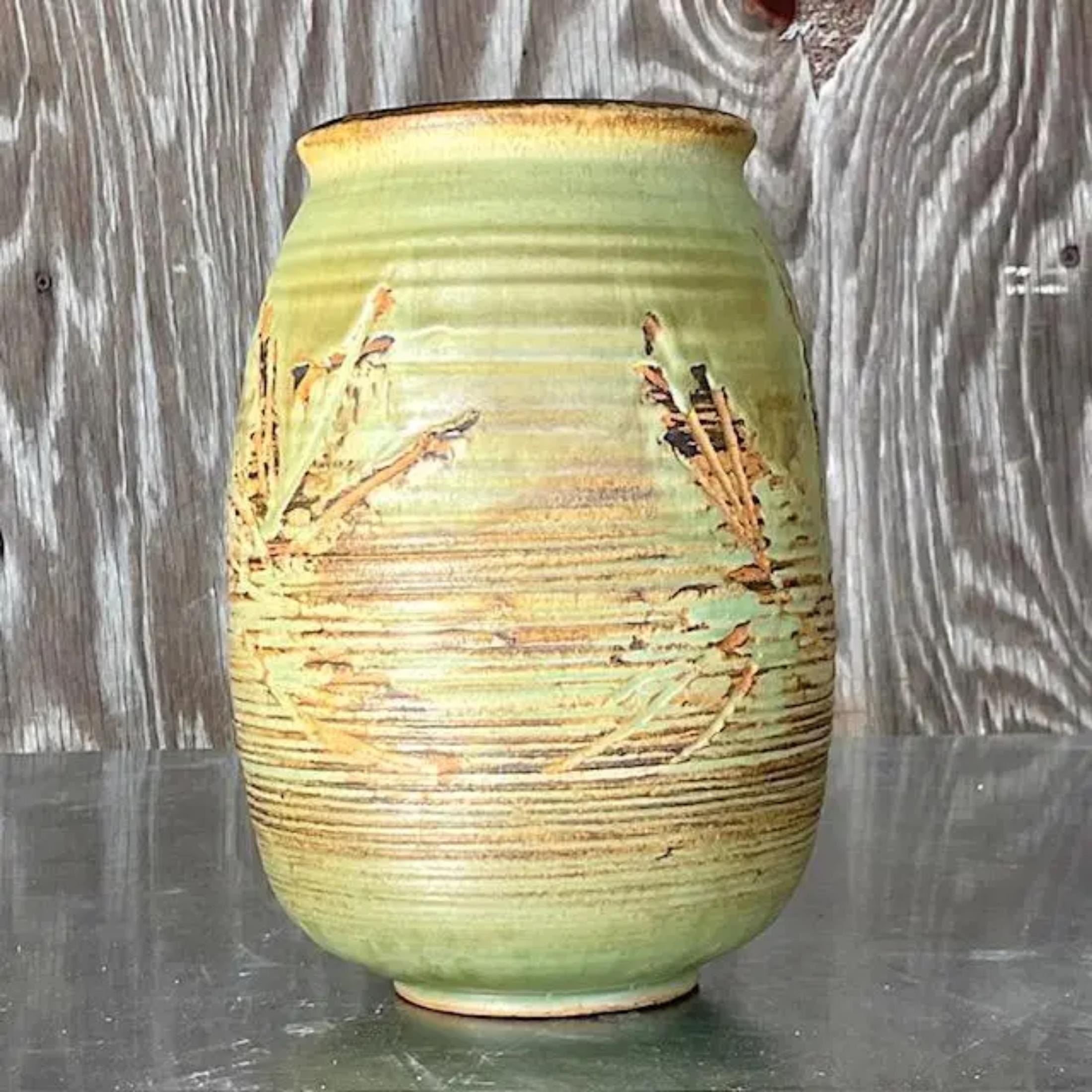 A gorgeous vintage Boho studio pottery vase. A chic green matte glazed finish with flashes of brown peeking thru. Signed by the artist. Acquired from a Palm Beach estate