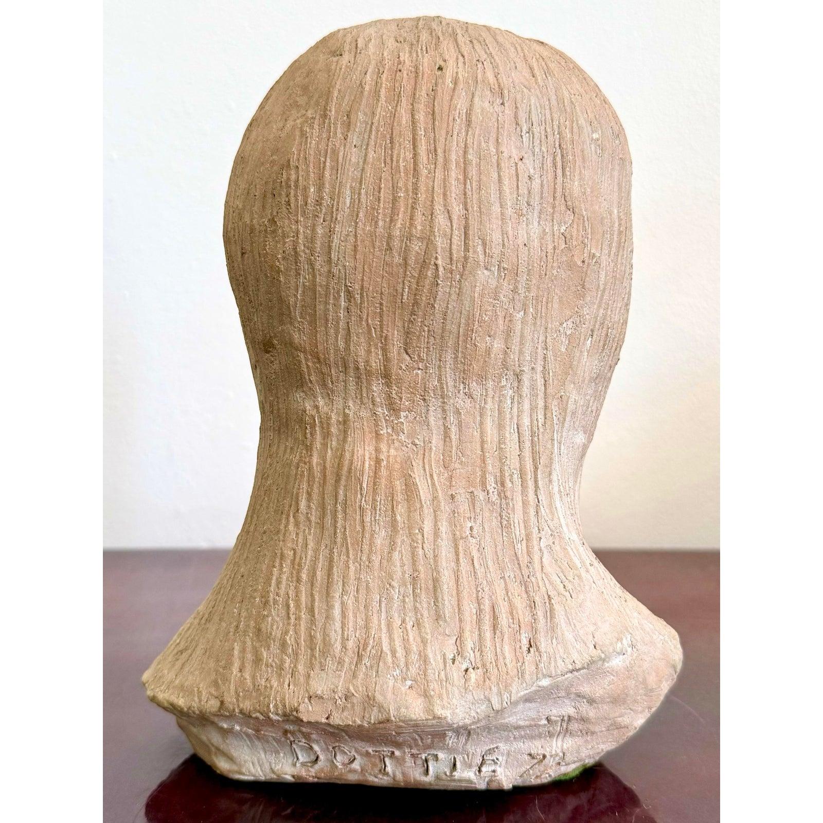 Questo busto in terracotta cattura una tranquilla introspezione, resa con cruda onestà tattile. L'espressione della donna è serena e allo stesso tempo indagatrice, con le labbra leggermente divaricate e lo sguardo rivolto verso il basso che