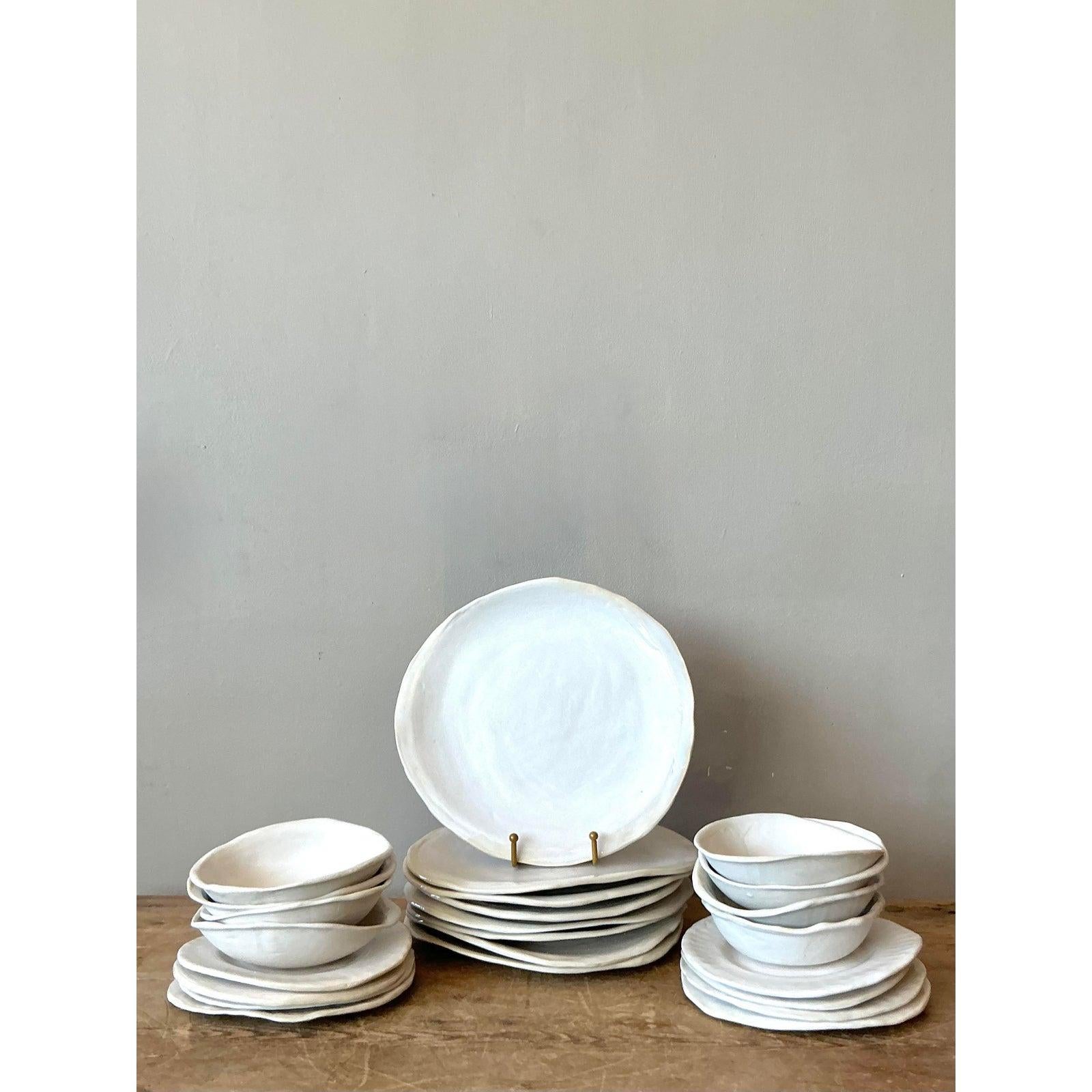 Elevate your dining experience with the soulful elegance of this 24-piece set of vintage studio pottery dinnerware. Masterfully handcrafted using slab-building techniques, each piece eschews machine perfection in favor of unique, freeform