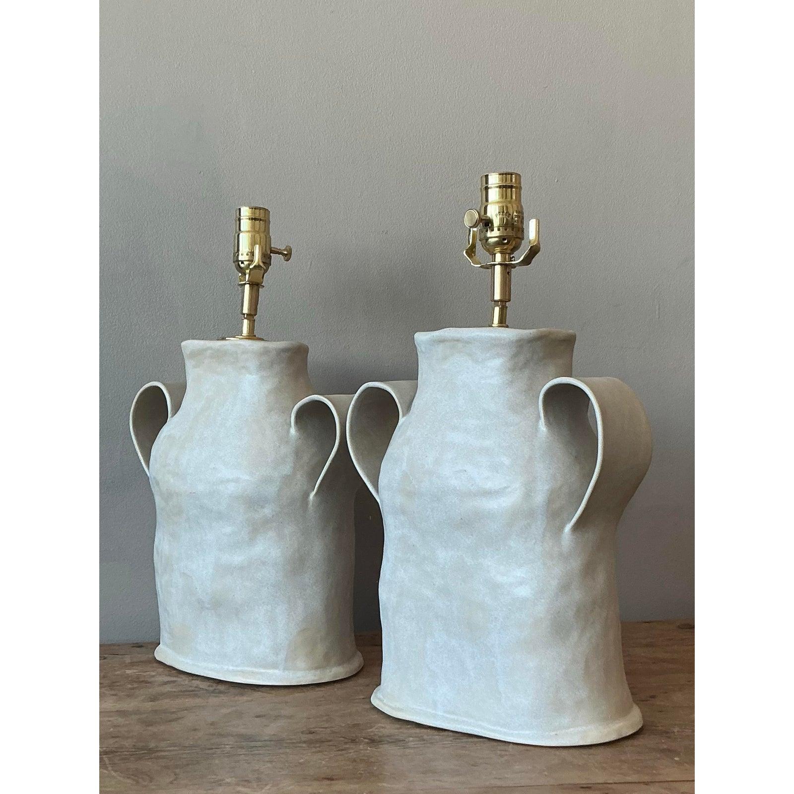 Illuminate your space with this captivating pair of vintage Boho slab-built studio pottery lamps, each a unique work of art reflecting artisanal craftsmanship. These lamps exude a natural, organic aesthetic, characterized by their textured surfaces