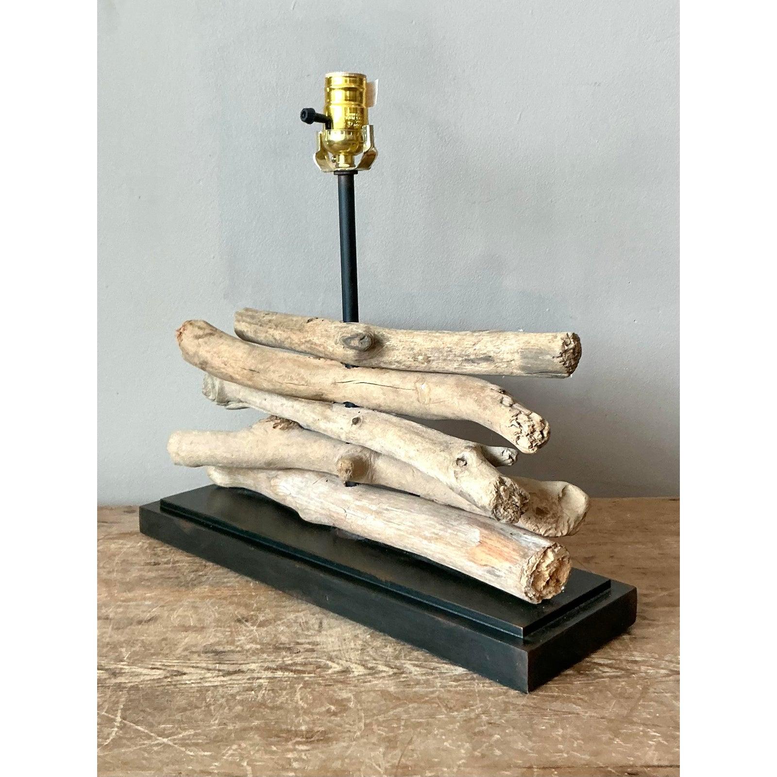 Bring the serenity of nature indoors with this sculptural vintage stacked wood table lamp. A striking example of Organic Modern design, the lamp features a series of sun-bleached natural branches, artfully stacked to create a textured, linear