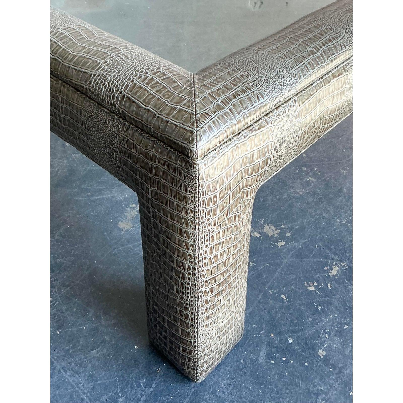 This exceptionally stylish coffee table is a bold expression of Postmodern and 1980s design, utilizing dramatic texture and architectural form. The robust square frame and cylindrical legs are entirely encased in a sophisticated, textured vinyl or