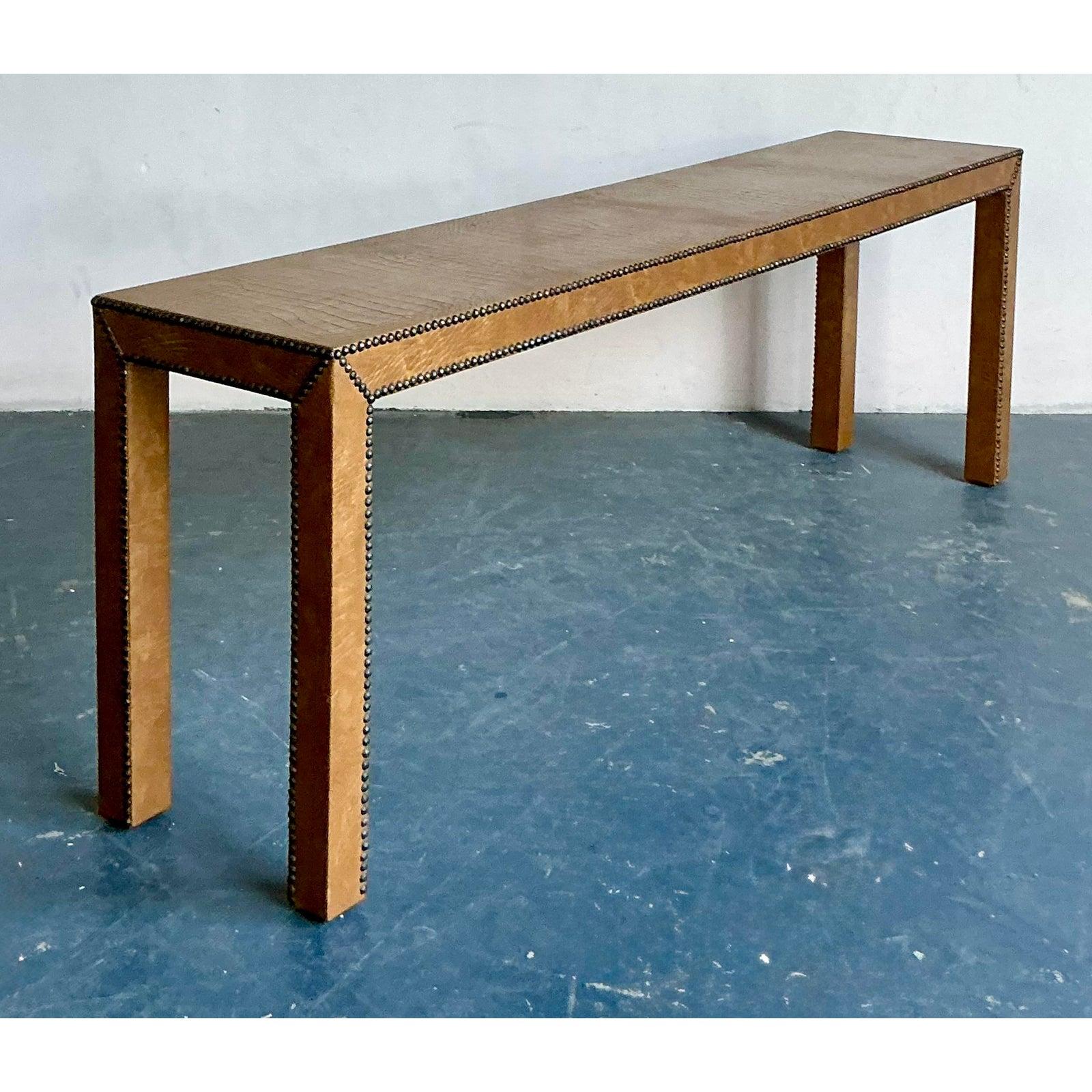 This exceptionally long and narrow console table makes a bold statement through its texture and detailing, combining the executive feel of high-end leather with rustic craftsmanship. The entire structure, including the tabletop and legs, is clad in
