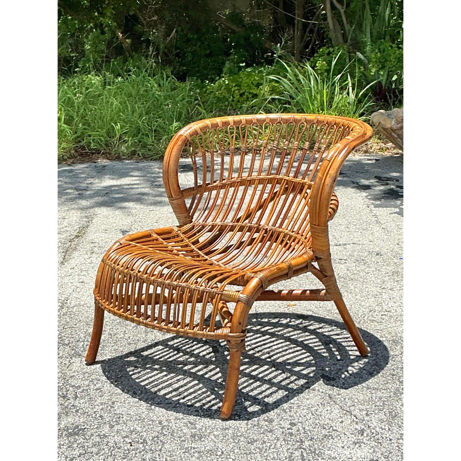 Canaliza un espíritu relajado y bohemio con esta exquisita tumbona vintage de ratán palo. Con un diseño clásico de respaldo de tonel, esta pieza es un bello ejemplo de artesanía hecha a mano, construida enteramente con ratán natural. El aireado