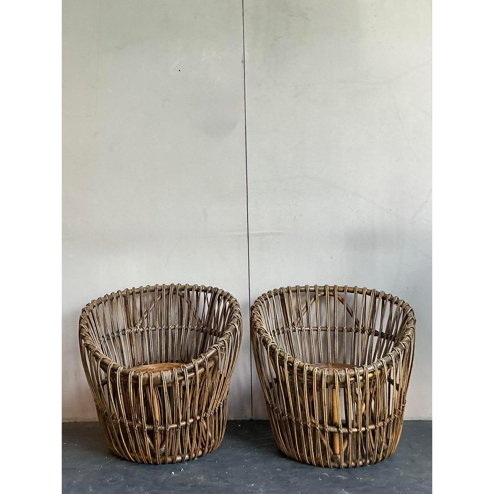 Embrace the effortless style of mid-century bohemia with this fantastic pair of vintage rattan barrel chairs. Each chair features a sculptural and inviting 