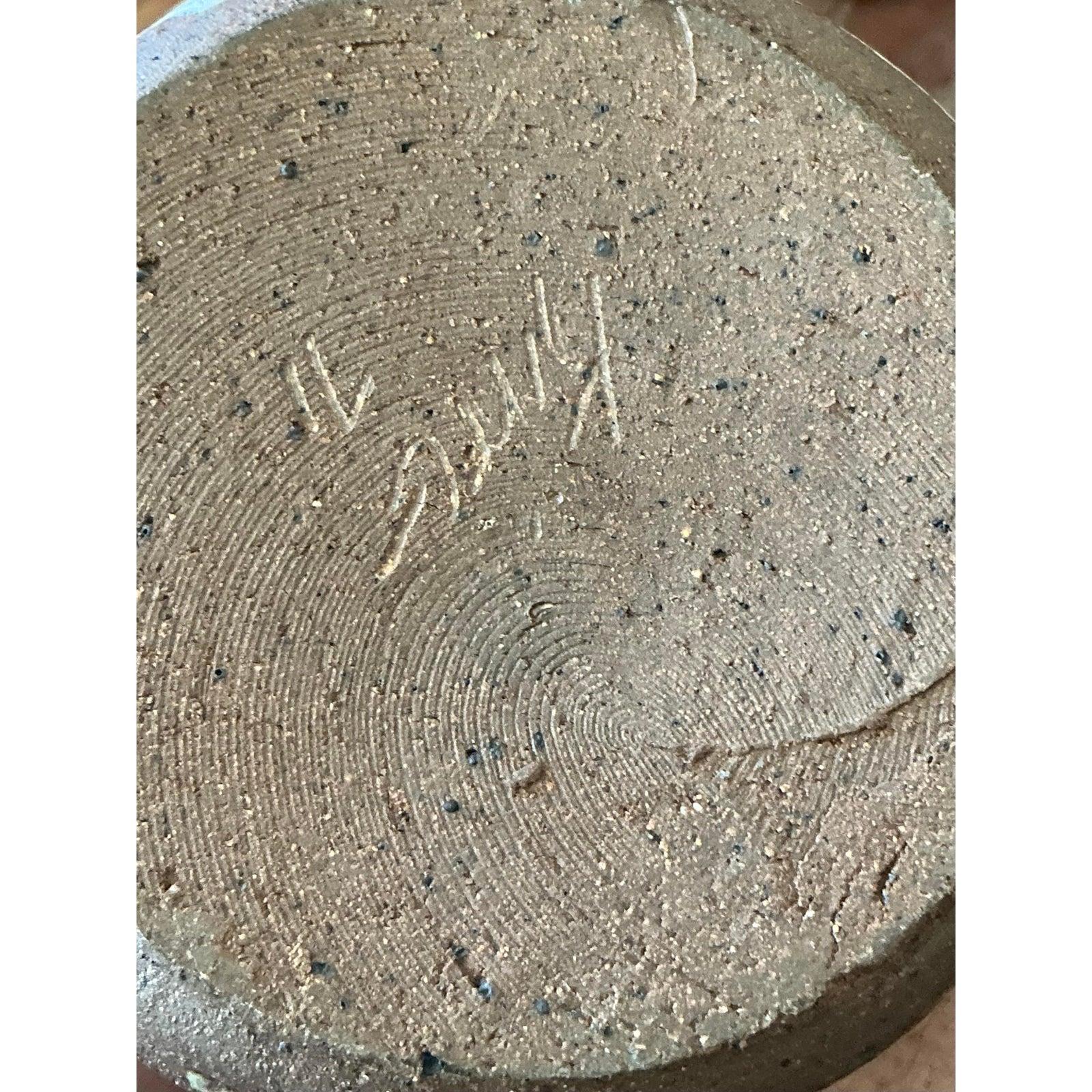 Dieser bezaubernde, vom Künstler auf dem Sockel signierte Vintage-Krug verkörpert auf wunderbare Weise die organische Ästhetik der Mid-Century Studio Pottery. Das handgedrehte Stück aus stark gesprenkeltem braunem Steinzeug ist mit einer taktilen,
