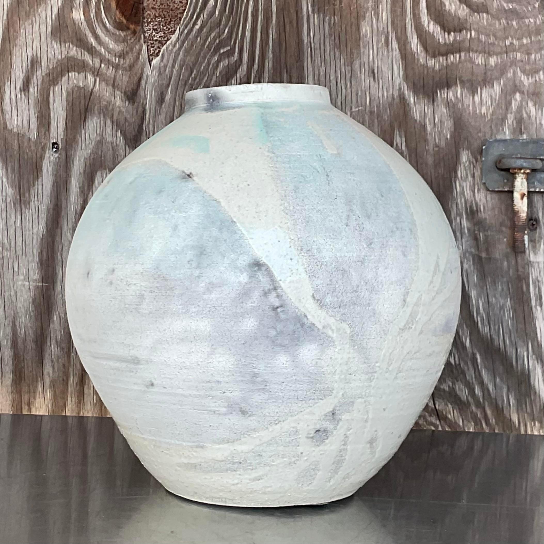 Fantastic vintage Boho studio pottery vase. A beautiful sphere shape with small lip at the top of the vase. A multi layered surface with lots of texture and the palest colors peeking through the glaze. Acquired from a Palm Beach estate. 