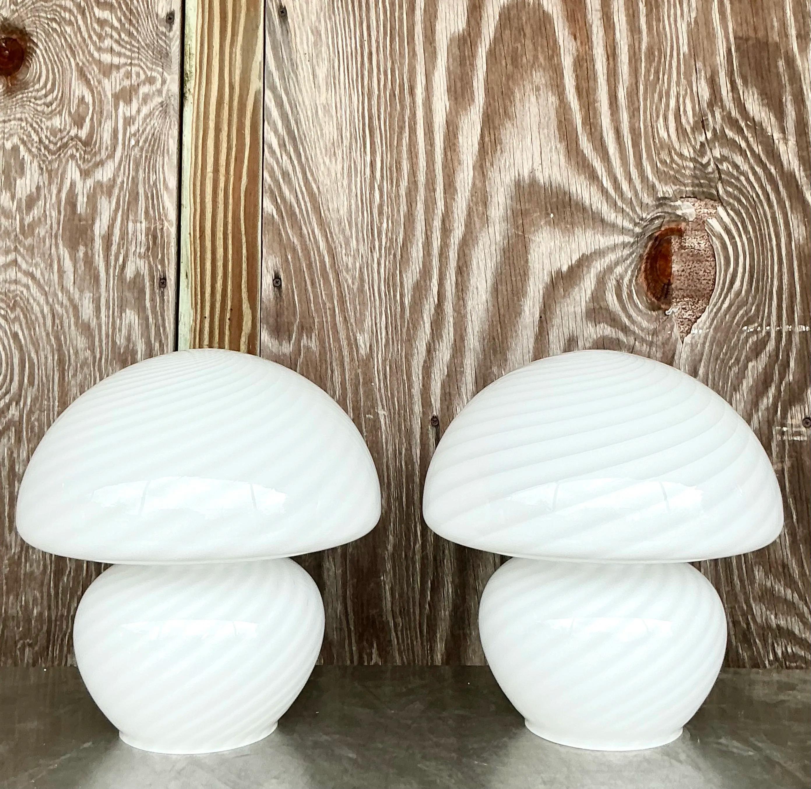 Elevate your space with this Pair of Vintage Boho Swirl Glass Lamps After Murano. Crafted in the iconic Murano-inspired style, these lamps feature exquisite hand-blown glass bases with mesmerizing swirl patterns in soft, neutral tones. The elegant