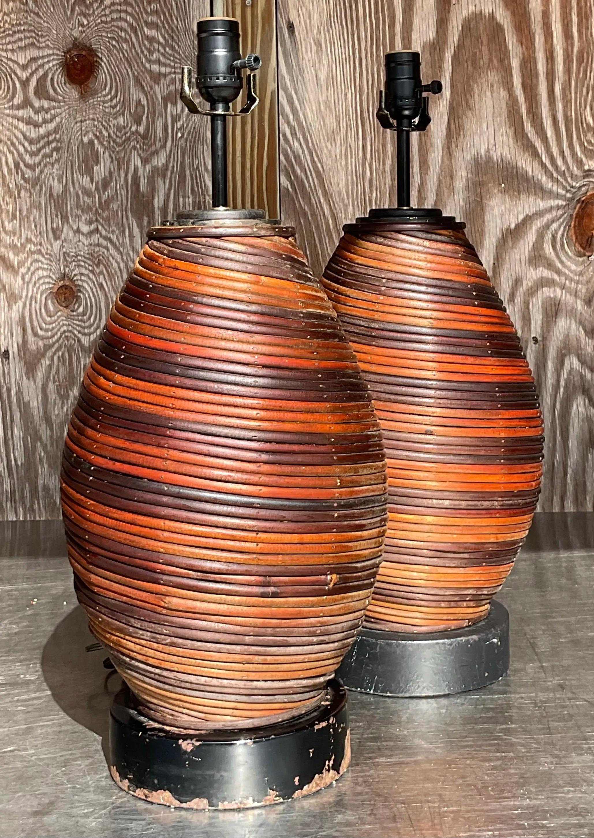 Aggiungi un tocco di charme organico al tuo spazio con questa coppia di lampade vintage Boho Swirl Pencil Reed. Realizzate con un'attenzione meticolosa ai dettagli, queste lampade presentano un sorprendente motivo a vortice che mette in risalto la