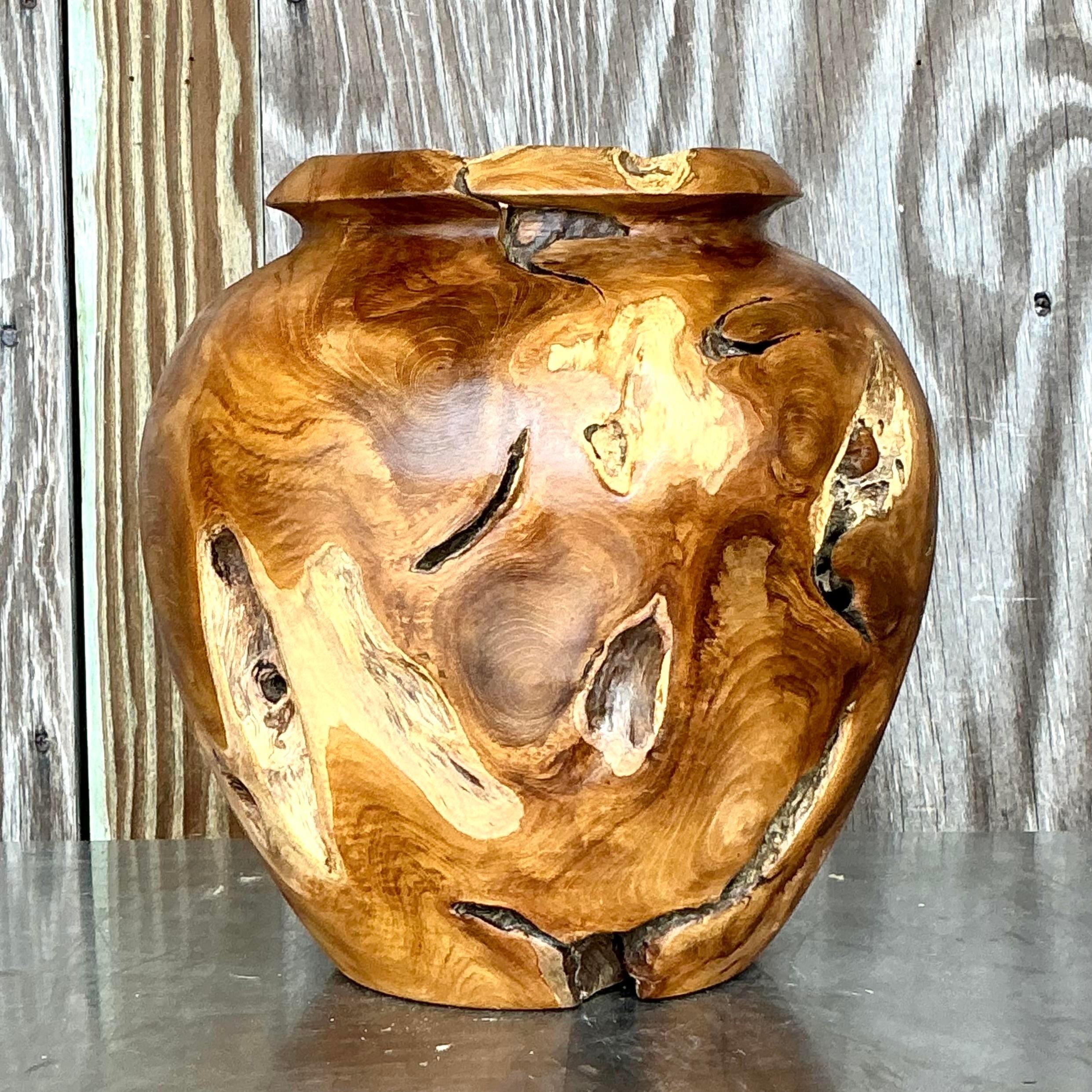 Introduci la bellezza naturale e l'eleganza bohémien nel tuo spazio con questo vaso vintage Boho in legno di teak tornito. Realizzato con maestria in un ricco e resistente legno di teak, questo vaso presenta un design elegante e tornito che mette in