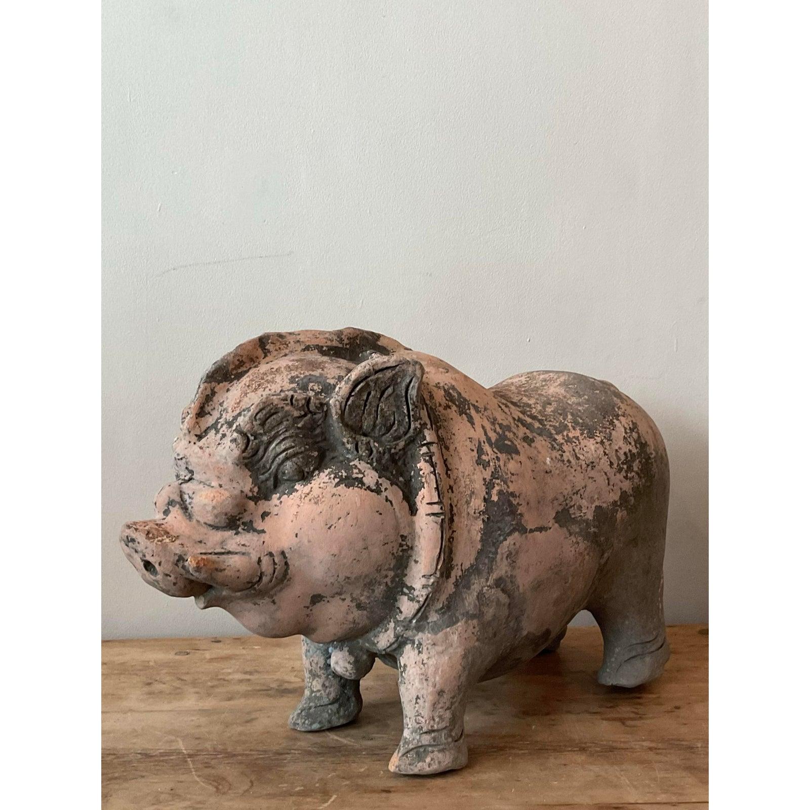 Questa affascinante scultura di maiale in terracotta vintage incarna un'estetica folk stravagante, perfetta per aggiungere carattere a qualsiasi spazio interno o esterno. Realizzato in robusta terracotta, il pezzo presenta una patina splendidamente