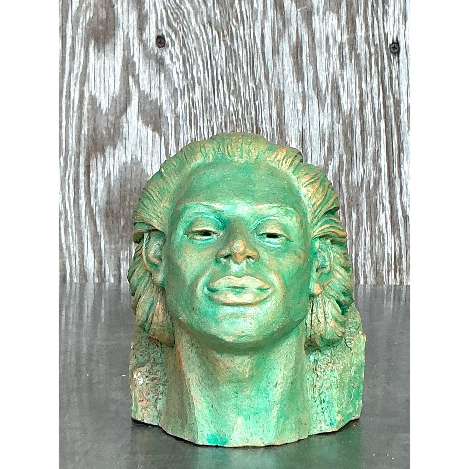 Questa splendida scultura vintage in terracotta cattura la serena eleganza di una donna dai capelli fluenti e dall'espressione pacifica. La sorprendente patina, nei toni del verde con sottili sfumature dorate, esalta il carattere invecchiato del