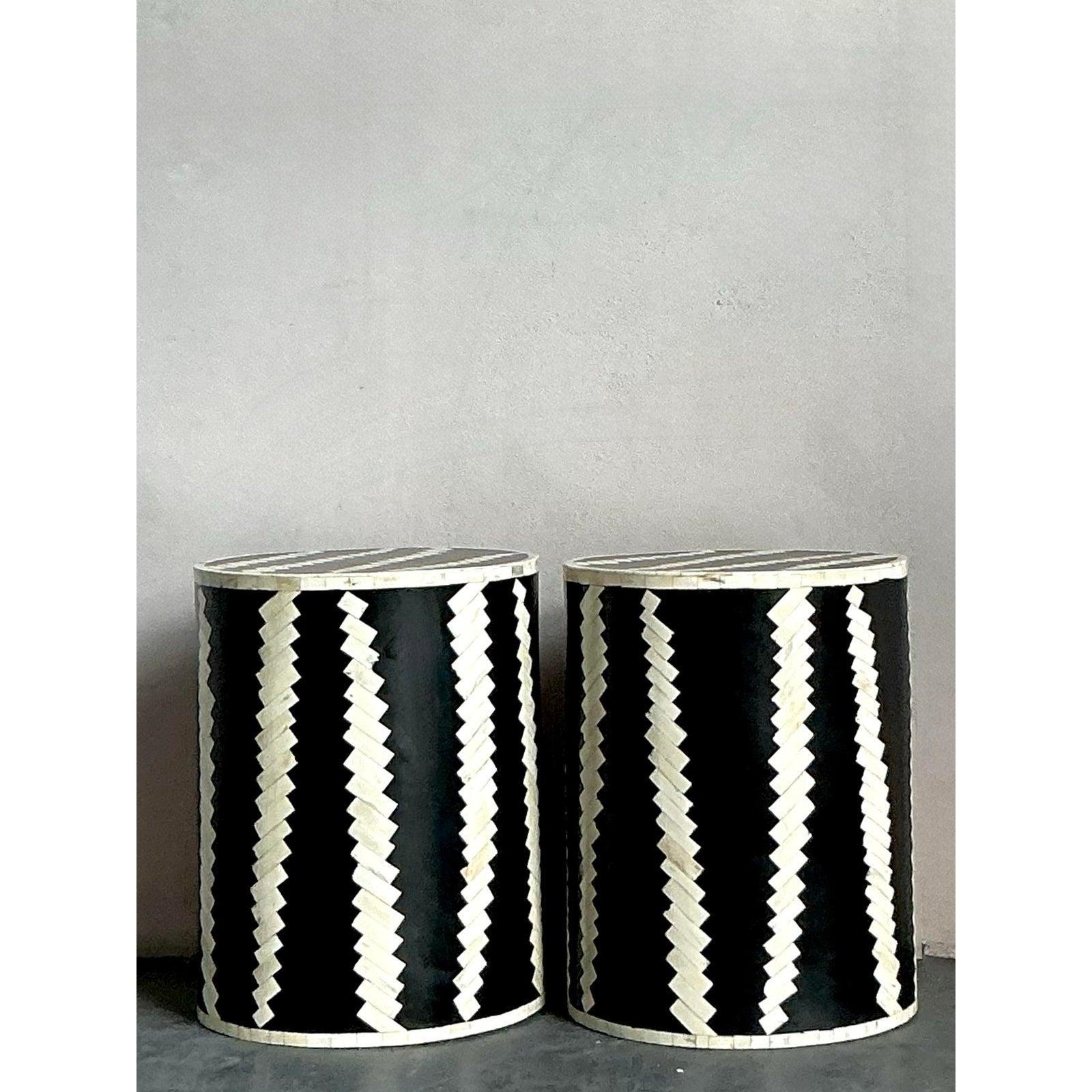 Eleva i tuoi interni con la raffinatezza grafica di questa coppia di sgabelli vintage a tamburo in osso tassellato. Realizzato con maestria, ogni sgabello presenta un intricato intarsio di ossa naturali e resina nera, disposte in un suggestivo