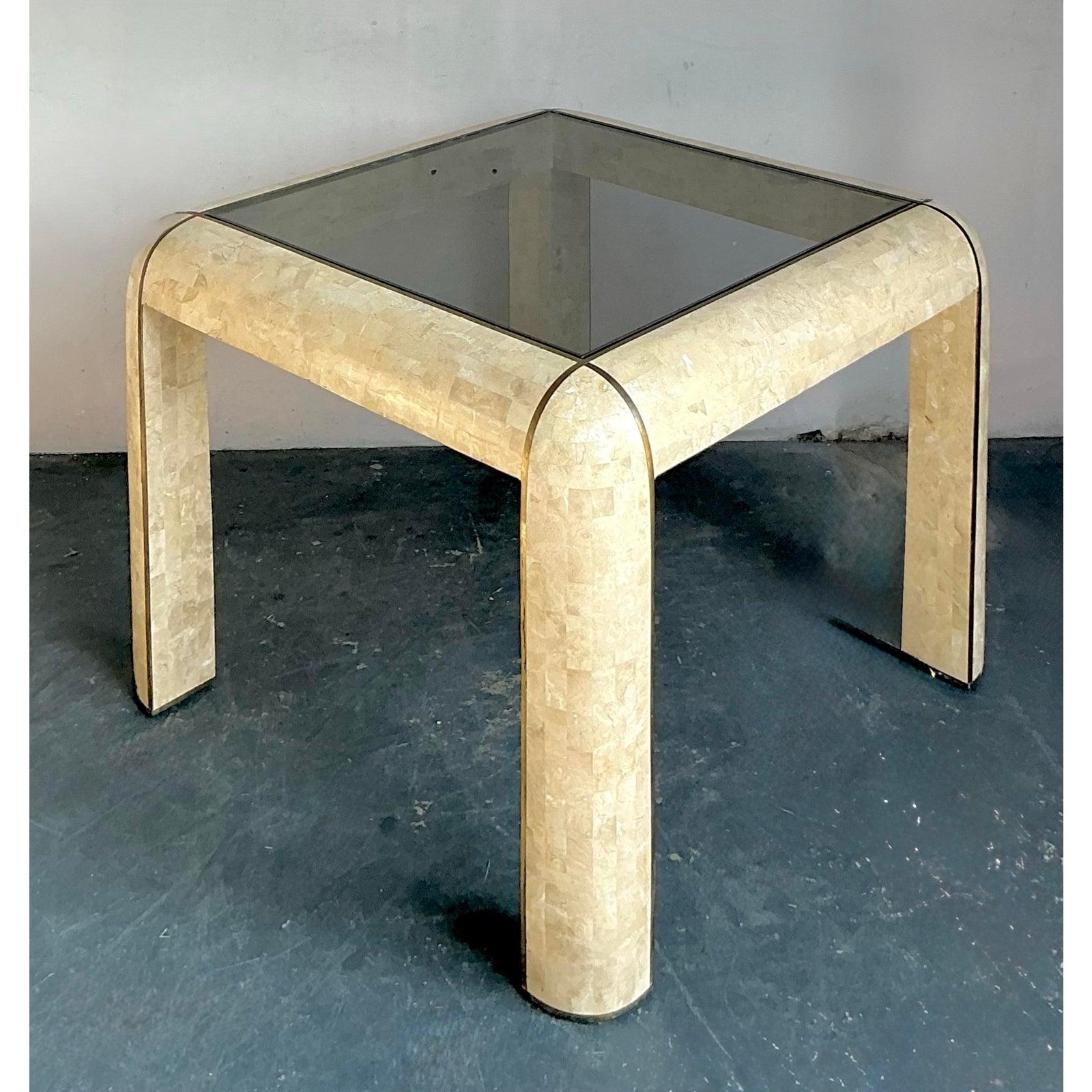 This distinctive side or dining table is a prime example of high-style Postmodern design from the 1980s, characterized by the striking use of tessellated stone. The substantial, waterfall-style frame is constructed from bone or lighter-toned natural