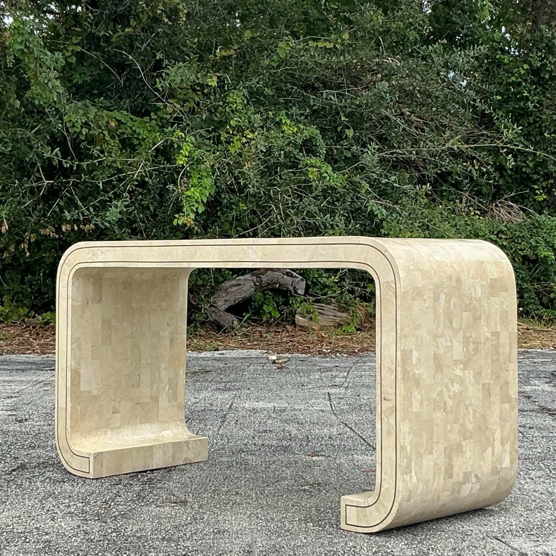 Elevate your space with this stunning vintage Maitland Smith tessellated stone scroll console table, a perfect blend of boho charm and timeless elegance. The intricate stonework and flowing scroll design create a captivating visual statement, while