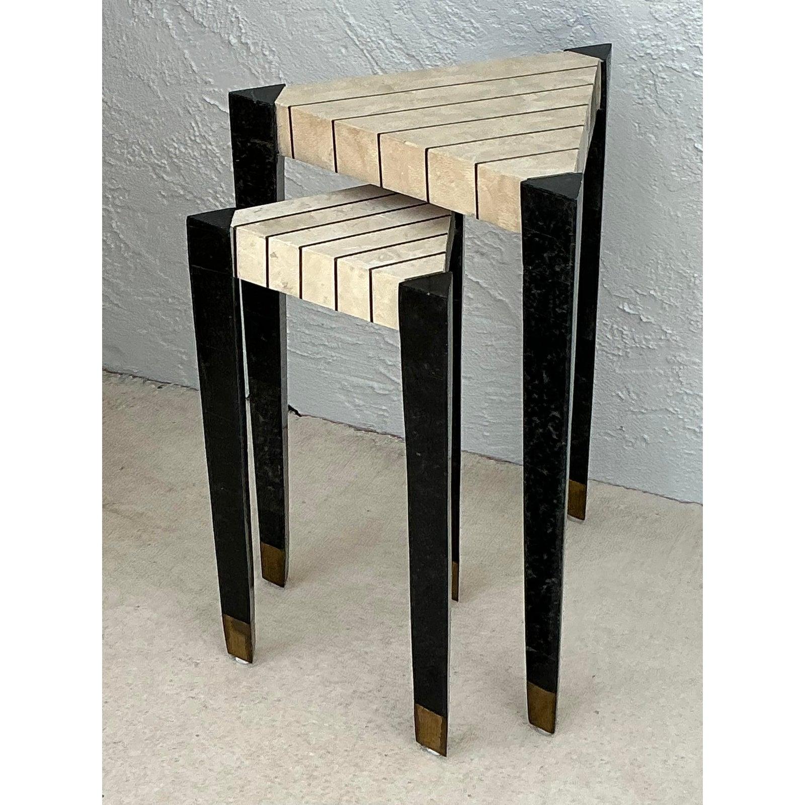 Voici une paire exceptionnelle de tables empilables vintage, exsudant la sophistication audacieuse caractéristique de l'époque Hollywood Regency. Ces pièces remarquables présentent d'élégants plateaux en pierre tessellée, composés de segments