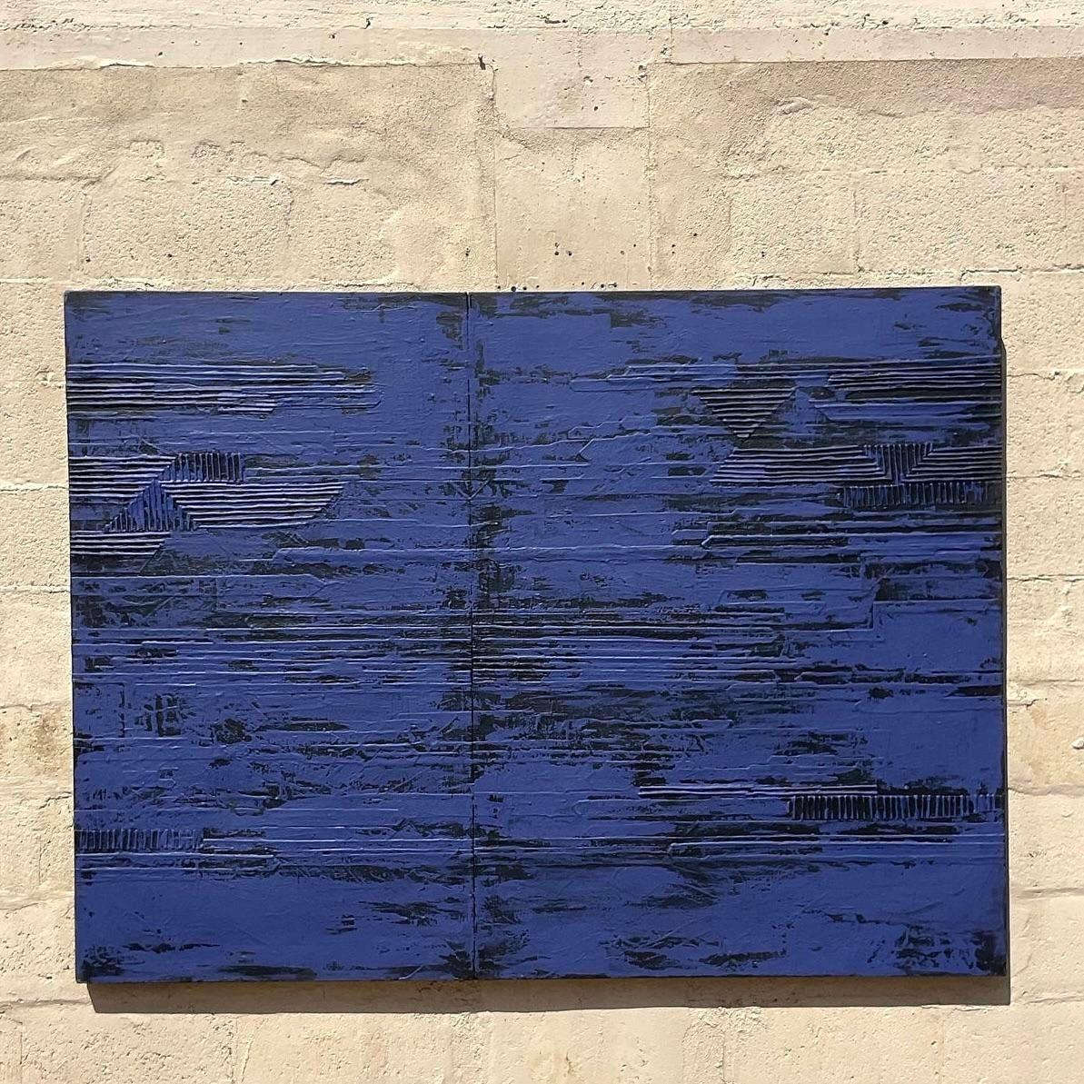 Cet abstrait apparemment minimaliste contient des détails cachés dans les dimensions de l'œuvre. La douceur du bleu marine et du noir apporte une touche subtile à l'espace, mais en y regardant de plus près, des éléments texturaux linéaires se