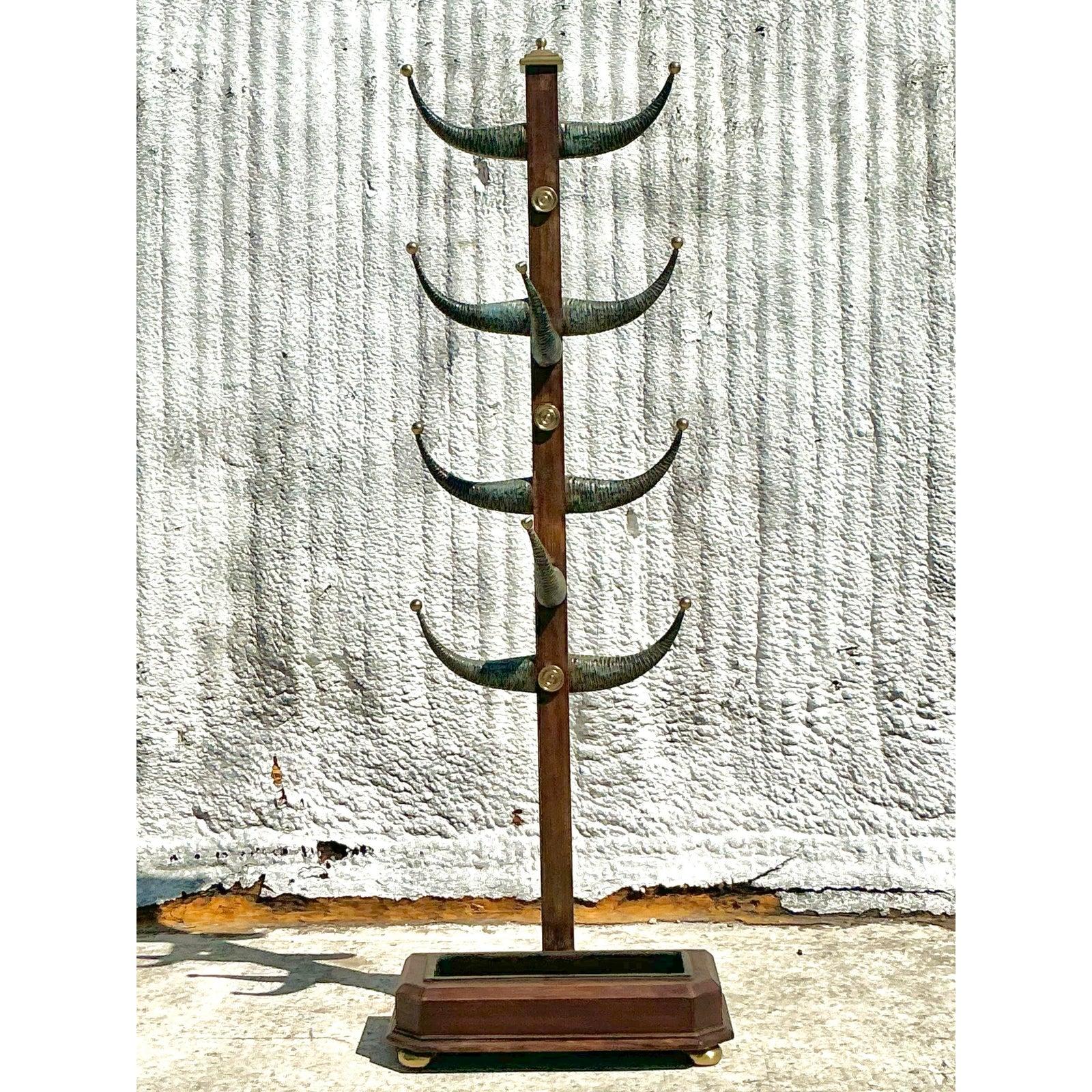 Elevate your space with this stunning vintage coat rack inspired by Tom Scheerer's signature bohemian aesthetic. Featuring a striking faux horn design, this statement piece blends rustic charm with refined craftsmanship. The rich wooden frame is