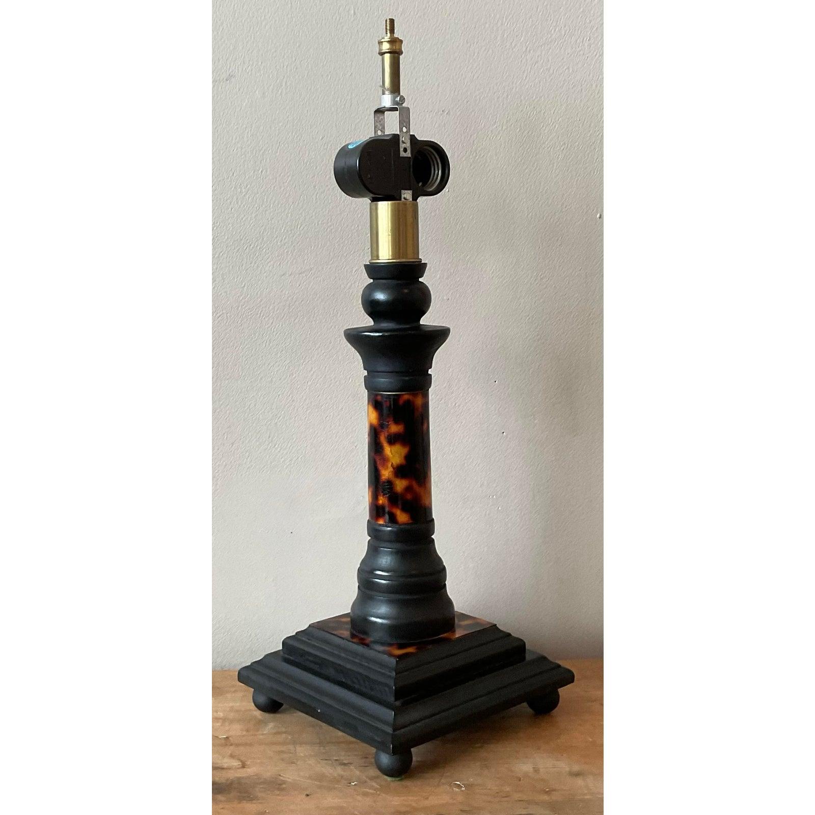 This striking vintage table lamp is a quintessential piece of Hollywood Regency and Boho-Chic design, blending sophisticated materials with a playful, eclectic style. The lamp features a stunning cylindrical body with a faux tortoise shell finish