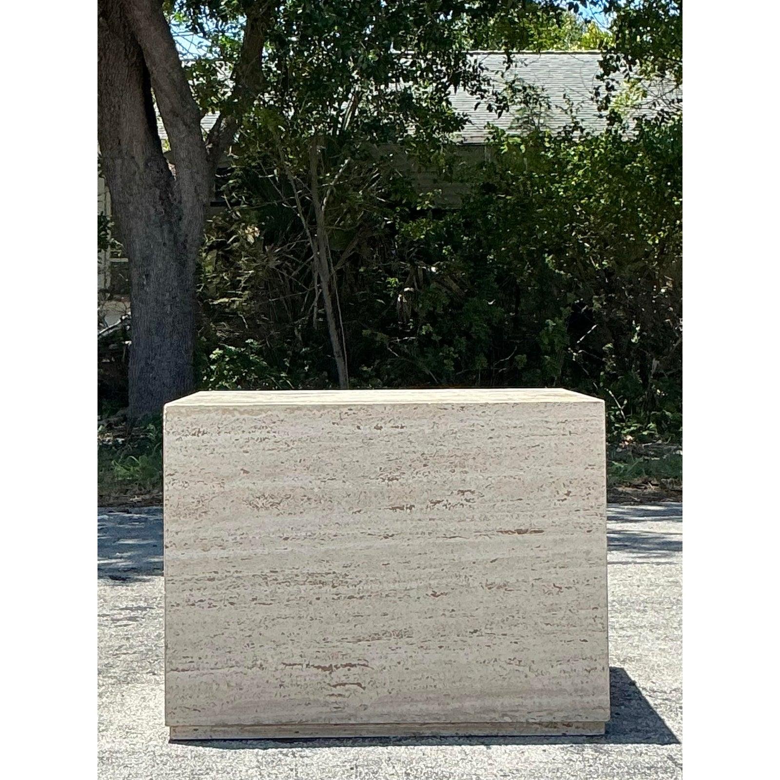 Introduci una presenza architettonica e una consistenza organica con questo tavolo a cubo in travertino vintage. Realizzato in travertino massiccio e splendidamente lavorato, mostra il calore caratteristico della pietra, le macchie naturali e le