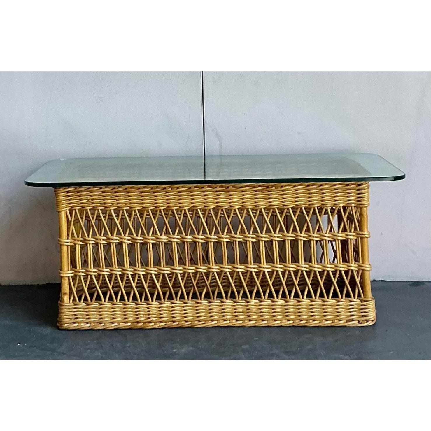 Ancla tu salón con la elegancia orgánica y desenfadada de esta mesa de centro vintage de ratán enrejado. Magistralmente tejida a mano, la base presenta un intrincado diseño de celosía de trama abierta que crea una maravillosa sensación de ligereza y
