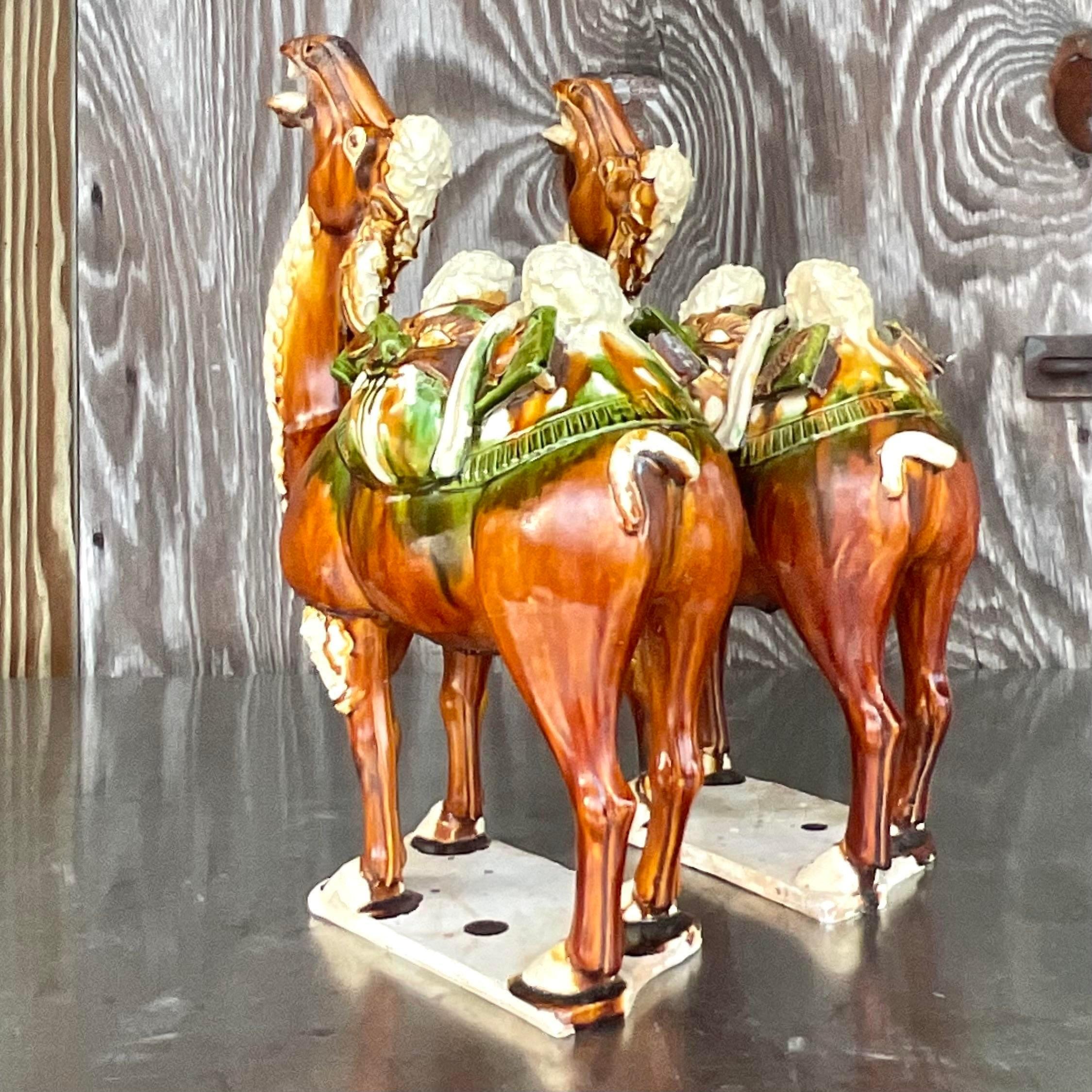 Una fantastica coppia di cammelli vintage in ceramica Boho. Un'elegante smaltatura Sancai tricolore su una coppia di belle figure. Acquistato da una proprietà di Palm Beach. 