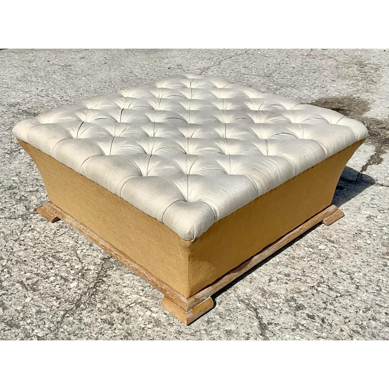 A fabulous vintage Boho ottoman. Beautiful tufted top in a linen cotton blend. The bottom half is upholstered in a beautiful burlap and rests on a cerused oak plinth. Acquired from a Palm Beach estate.