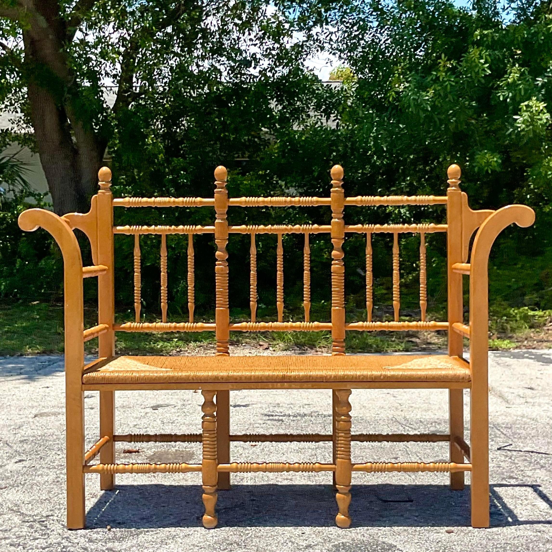A fabulous vintage Boho bench. A chic turned wood spindle design with a perfect rush seat. Sure to add a flash of charm to any space. Acquired from a Palm Beach estate. 