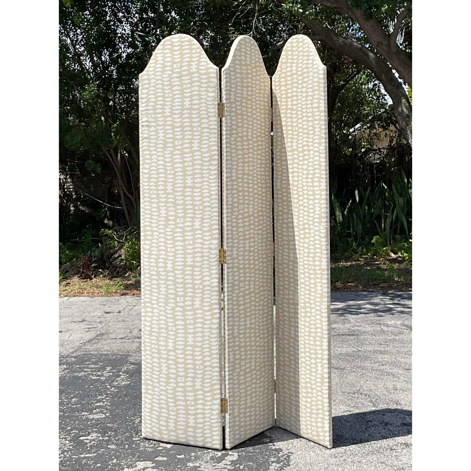 Add a touch of soft elegance and functional charm with this Vintage Boho Upholstered Folding Screen. Featuring three arched panels and wrapped in a neutral ivory and beige patterned fabric, this screen blends modern bohemian style with classic